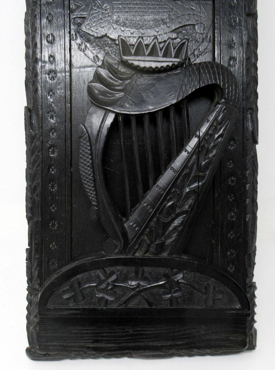 An extremely rare Irish hand carved bog oak book slide of good size proportions, mid-19th century, of outstanding quality and condition. The adjustable base with all-round Laurel Leaf decoration and a central split carving depicting a view of