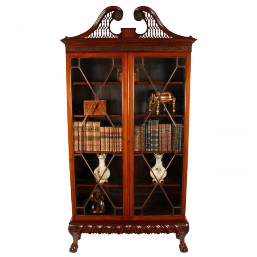 A late 19th to early 20th century Irish Chippendale style mahogany cabinet bookcase.

The cabinet stands on four bold cabriole legs with claw and ball feet and a deep carved frieze in-between.

The cabinet has a pair of astragal glazed doors and