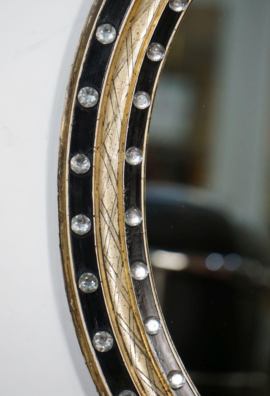 Ovaler Spiegel aus irischem Ebenholz und vergoldet mit facettierten Glasnieten (H 24 3/8 x B 20 1/2)  (Facettiert) im Angebot