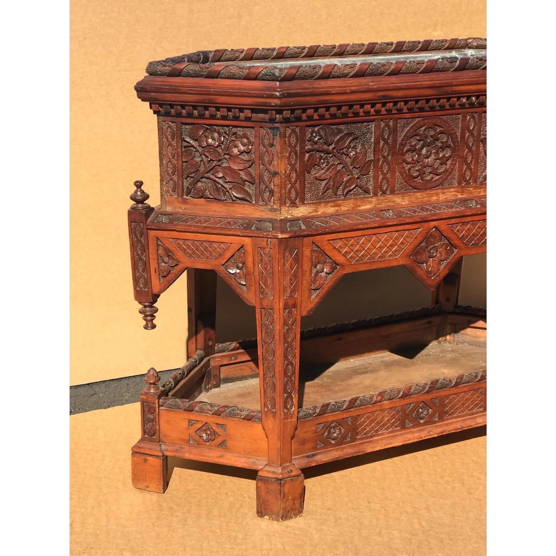 Unusual ornately carved two part mahogany planter, with original tole liner. Finely carved with life-like roses on side panels, the skirt, with a ribbon carved rim.  Made in Ireland, circa 1860.