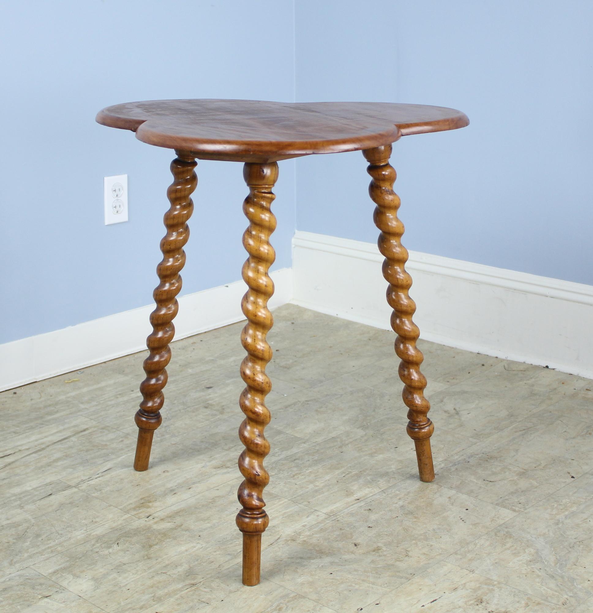 A whimsical gypsy table, which is often characterized by three flared turned legs and a stylized top, often reflecting the culture of its place of origin, in this case, Ireland. This piece is sturdy and attractive with good barley twist legs and a