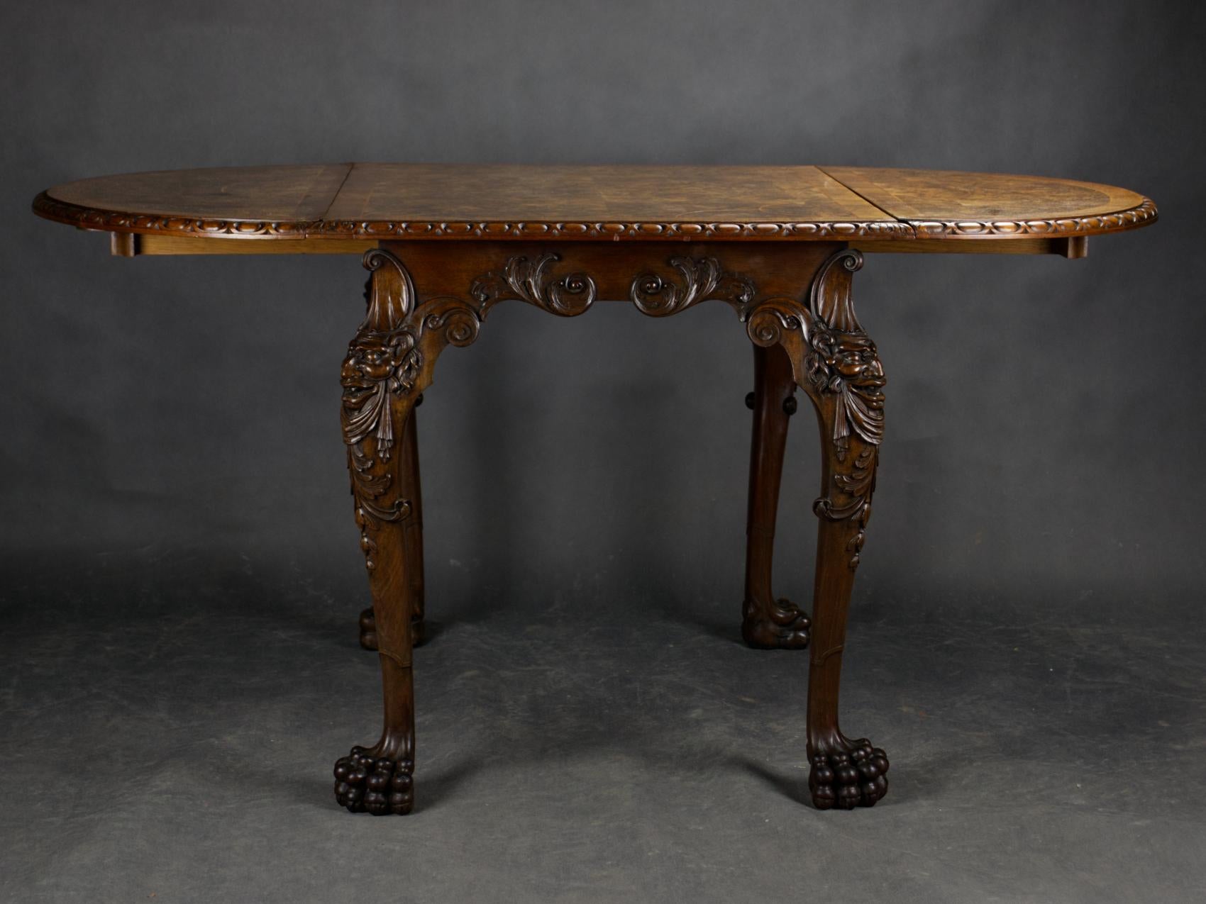 This exceptional Irish dining table from the 19th century is an example of masterful craftsmanship and detailed processing characteristic of the Georgian revival period. Made of solid walnut, the table features robust legs adorned with precisely