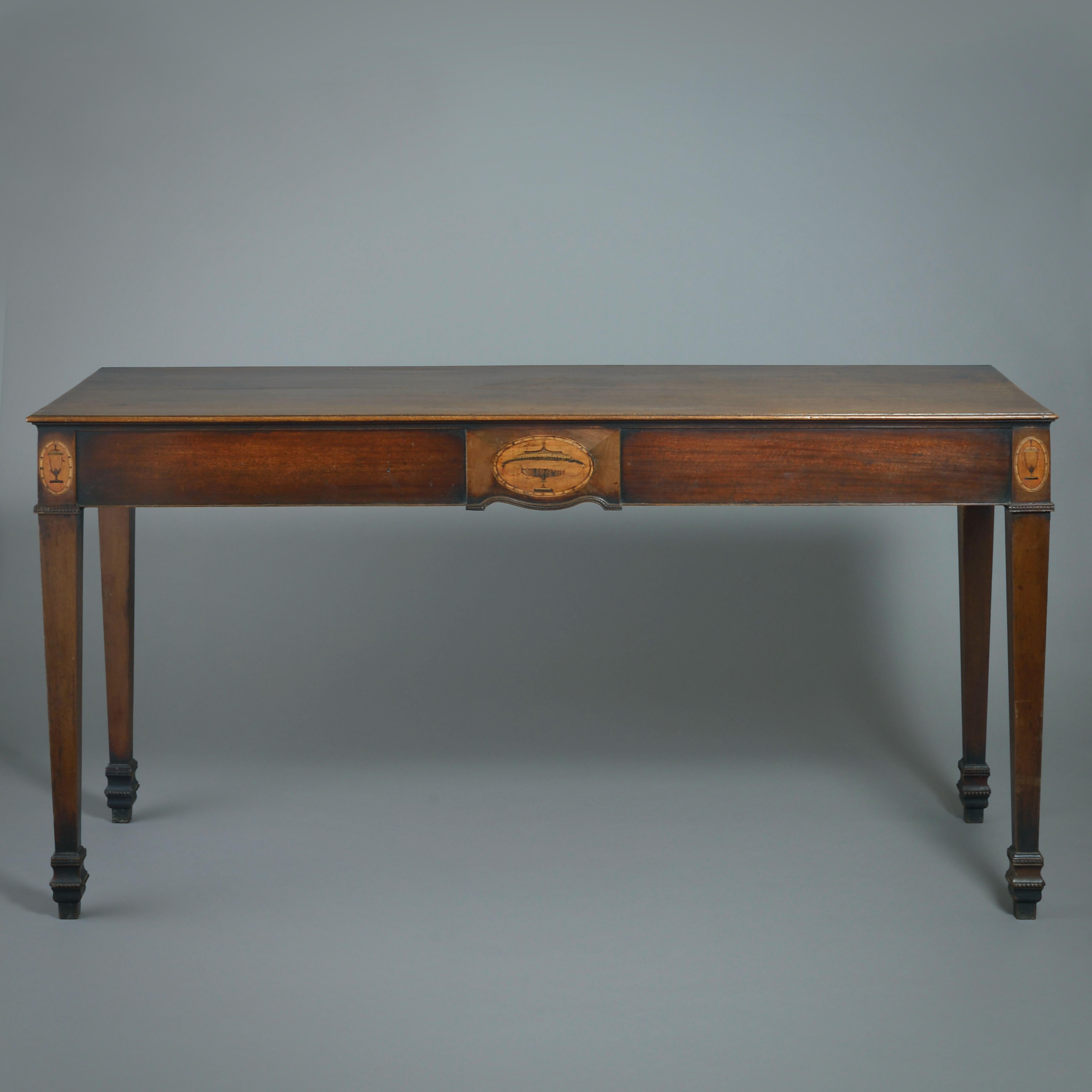 A FINE IRISH GEORGE III MARQUETRY-INLAID MAHOGANY SIDE TABLE, CIRCA 1780.

The shaped frieze centred by an oval panel inlaid with an urn, the square tapering legs headed by similarly inlaid panels.