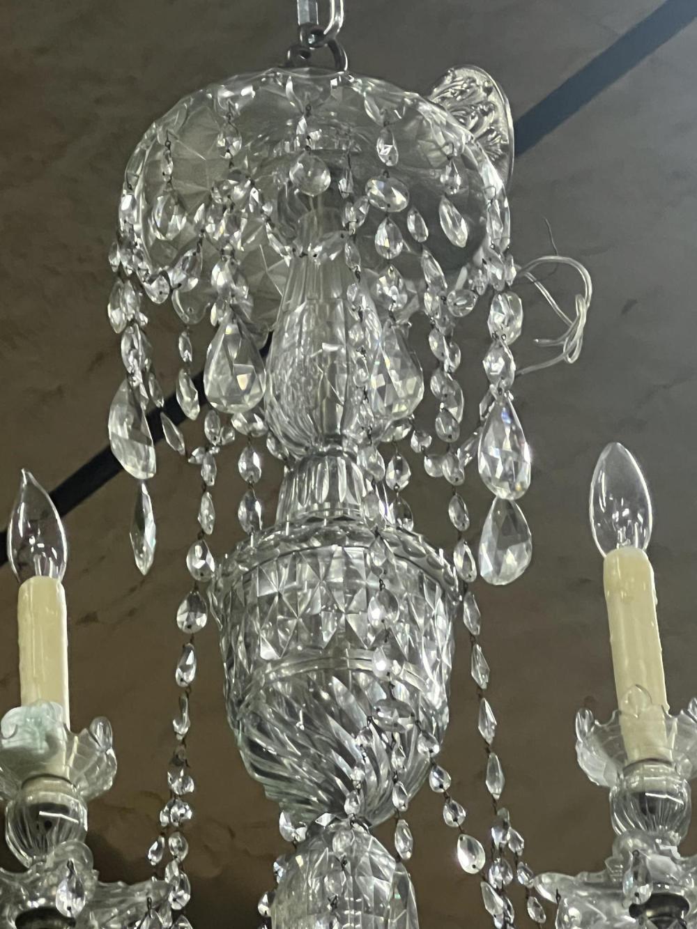 Hand Cut Irish Crystal Eight Arm Chandelier.  All original.  Eight blown and cut arms issuing from central bowl.  Georgian urn formed central shaft with upper canopy and swags or tear-shaped crystal chains.  A beautifully classic form from County