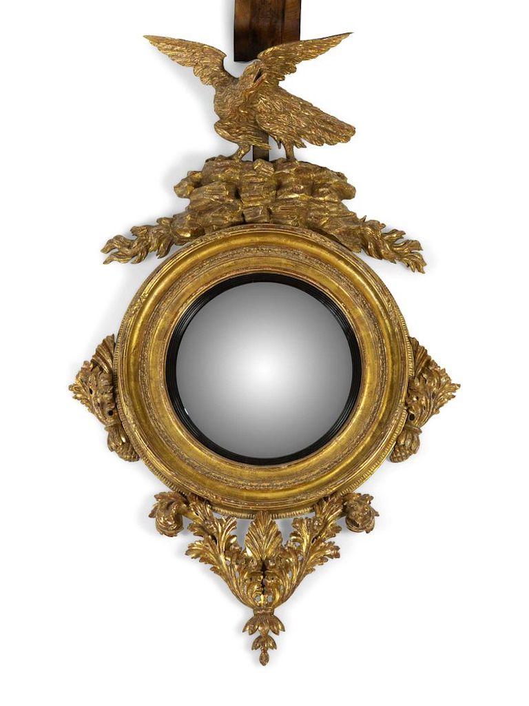 An Irish giltwood convex mirror, Irish Georgian or very early Regency eagle surrounding flames,
early 19th century
Measures: Height approximate 60 x width 36 inches.
Provenance:
Clinton Howell Antiques & Fine Art, New York, New York.
