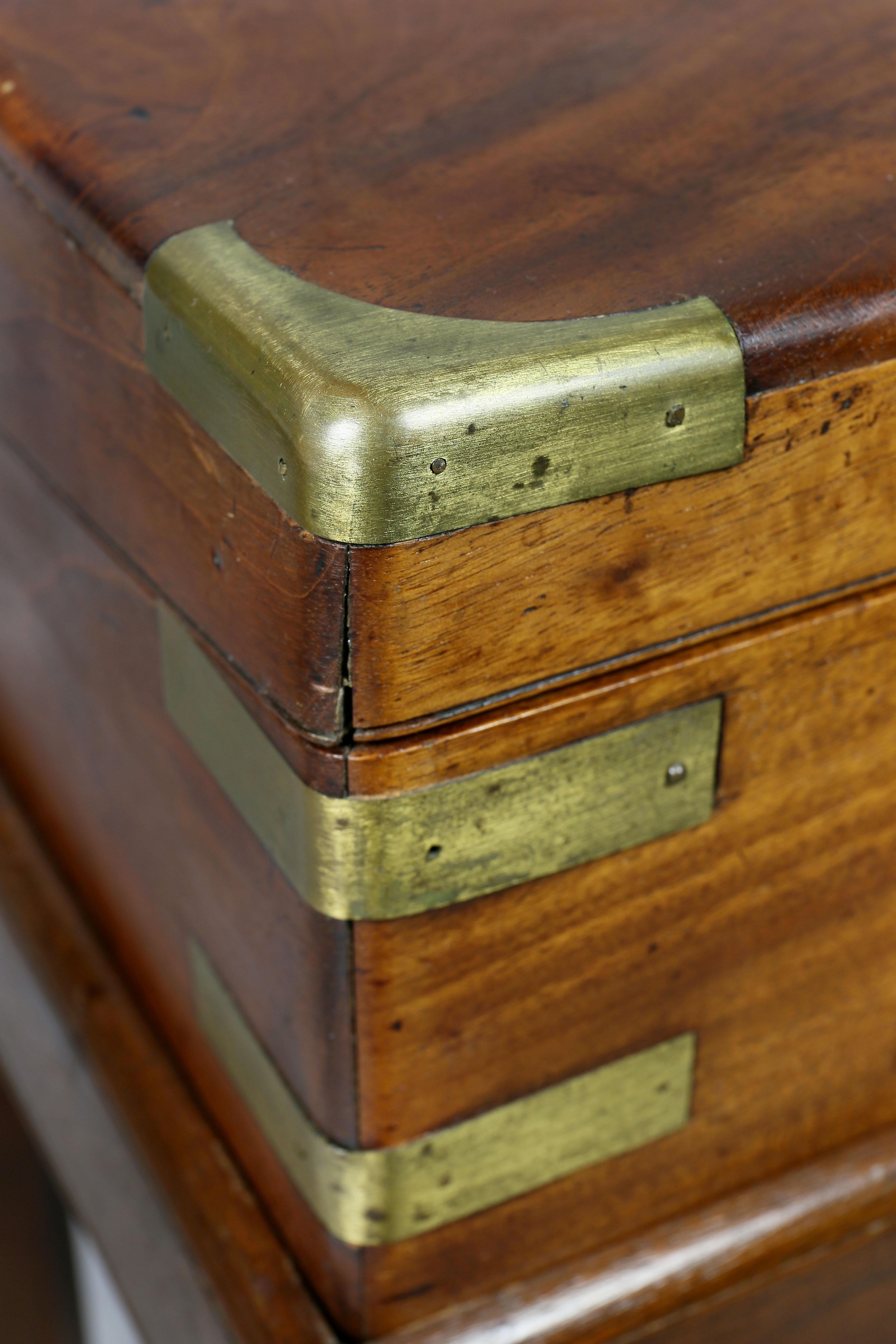 With a hinged lid with brass inlay opening to a desk section. Bears label, 