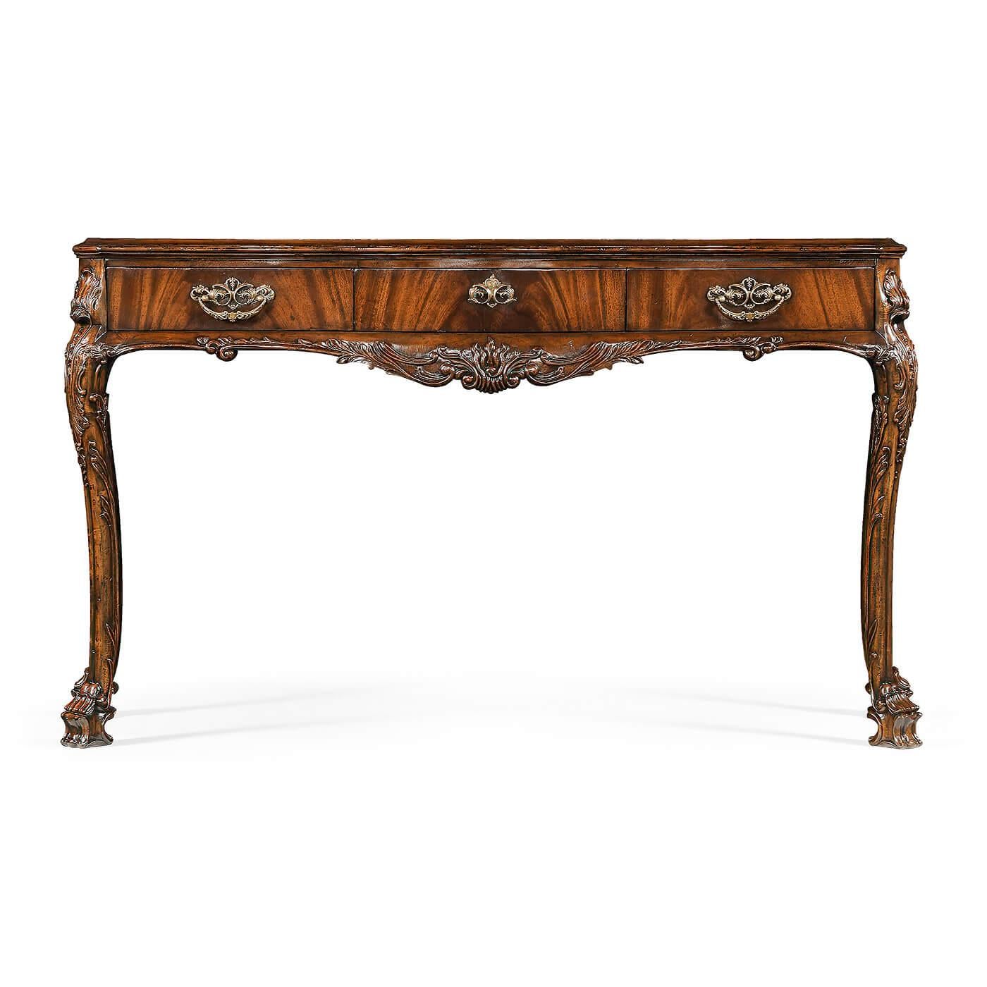 An Irish George II style mahogany veneered rococo style console table with fine shallow carved floral details to legs, oak secondary woods and a single long drawer standing on four cabriole legs with carved and stylized lions paw feet.