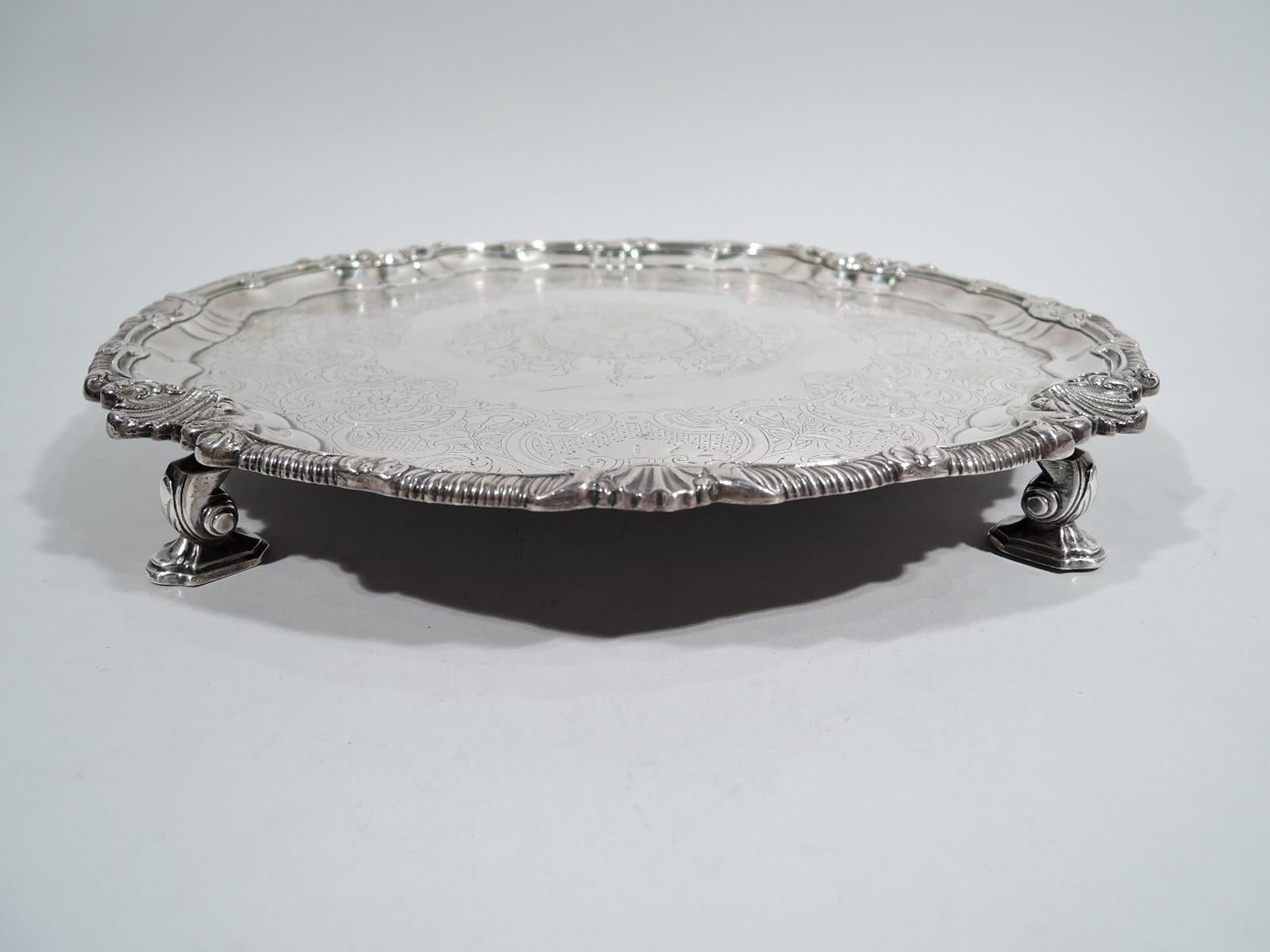 Irish Georgian sterling silver salver. Made by John Letablere in Dublin, mid-18th century. Gadrooned rim interspersed with shells and flower heads. Well center has engraved armorial with sword-bearing hand surrounded by flowers, leaves, and