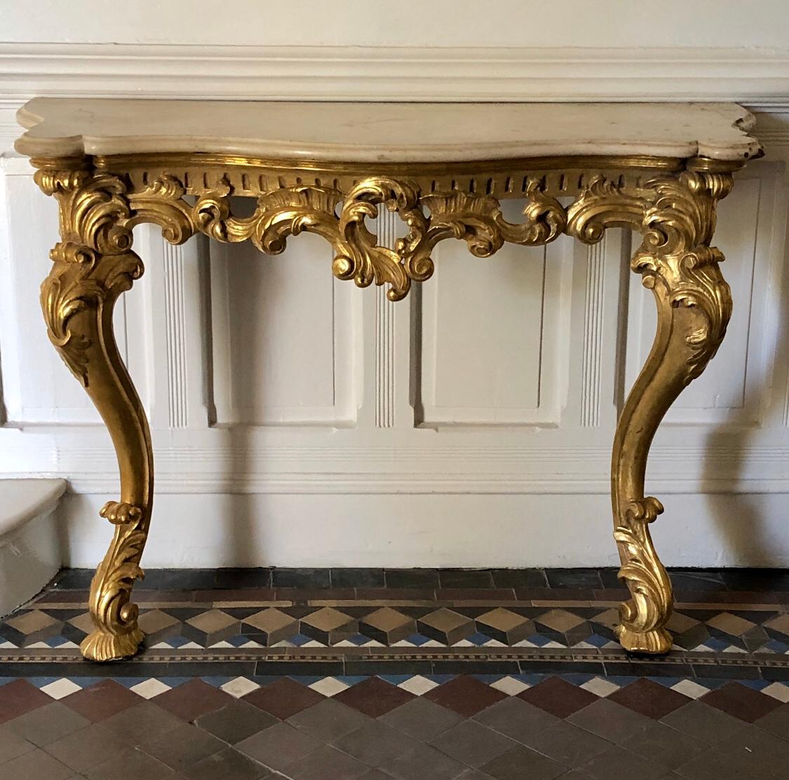 This Irish Rococo console has carved gilded wood cabriole legs and white marble top with cabinet makers stamp 