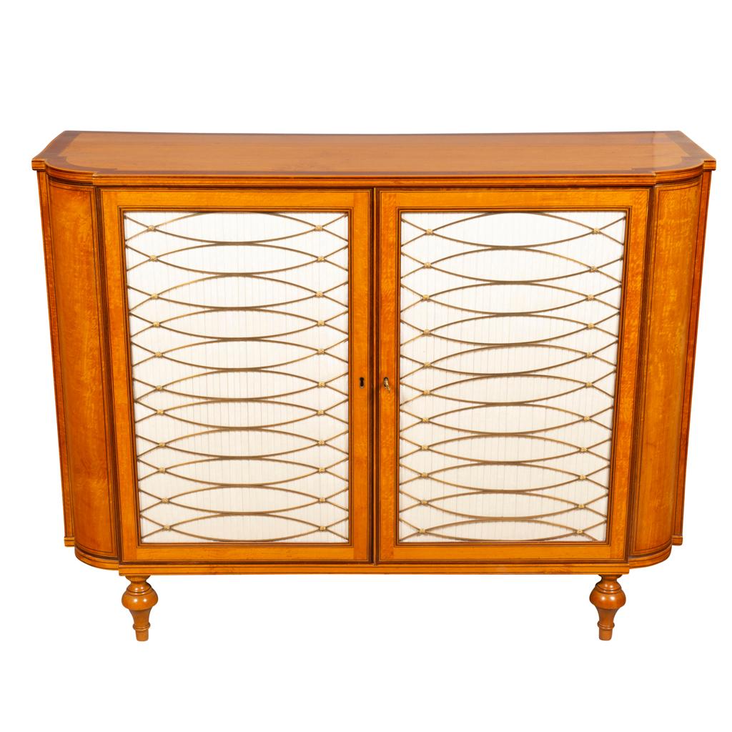 Rectangular top with rounded ends with banded edge over a pair of doors with brass grillwork. On turned toupie feet. Provenance; Partridge Fine Arts, London. Christies London Nov 27, 2003. Lot 112.
