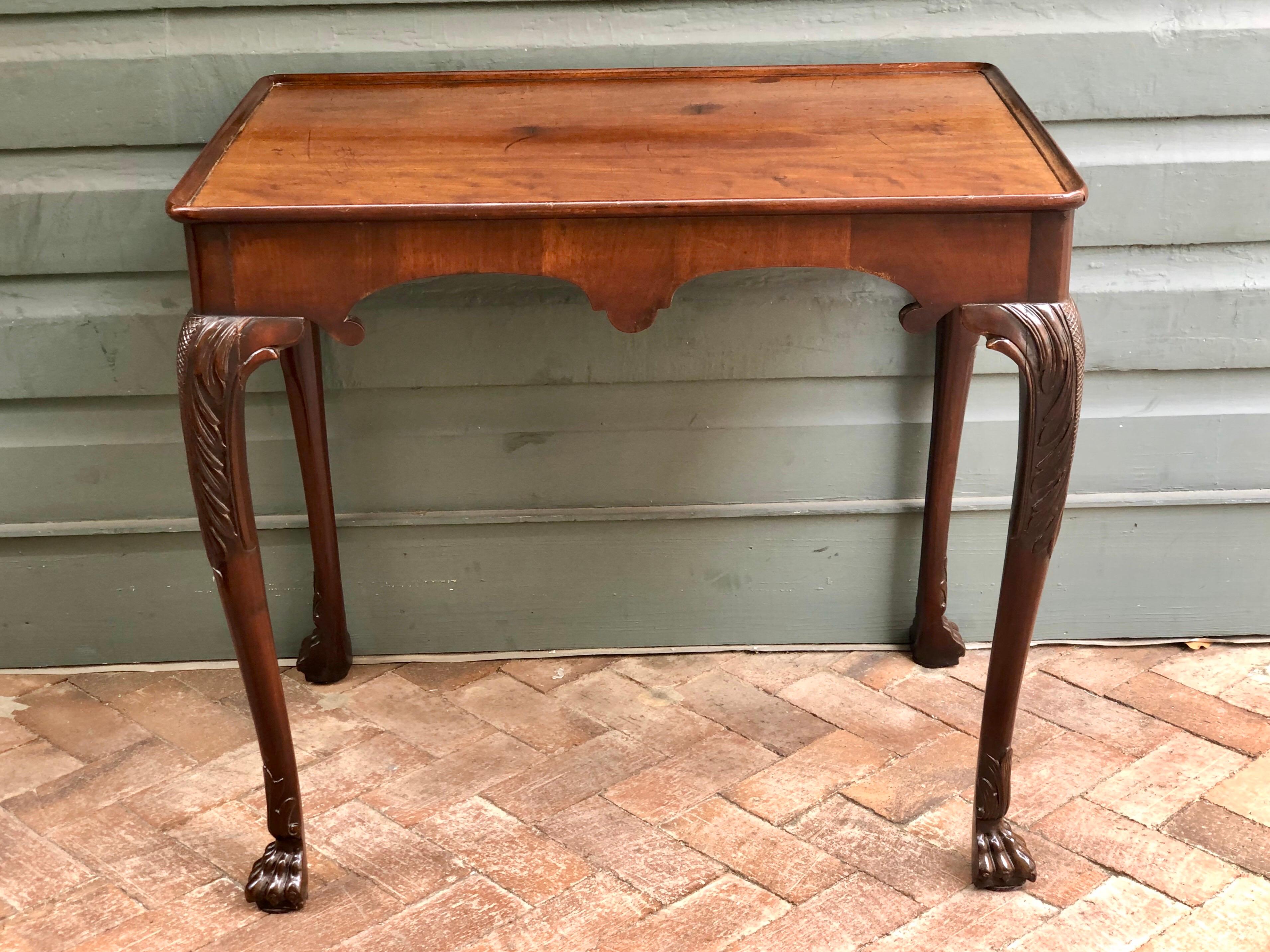 This Irish tea table is made of Cuban mahogany with rich patination in the finest style. The top of the table is one single mahogany board carved to a dish top design. The simplicity of the carved frieze has a sophisticated elegance with its Queen