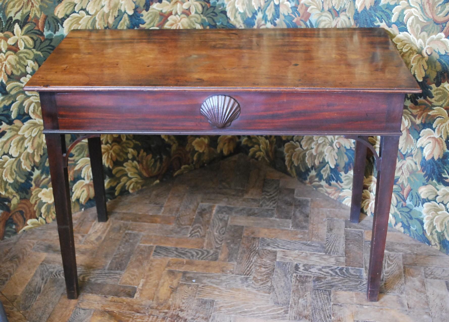 Charme Antiques est fier de présenter une charmante table d'appoint en acajou irlandais, datant d'environ 1770. Cette pièce exquise reflète l'influence durable du style Chippendale, avec des consoles ouvertes et des tiroirs à chaque extrémité,