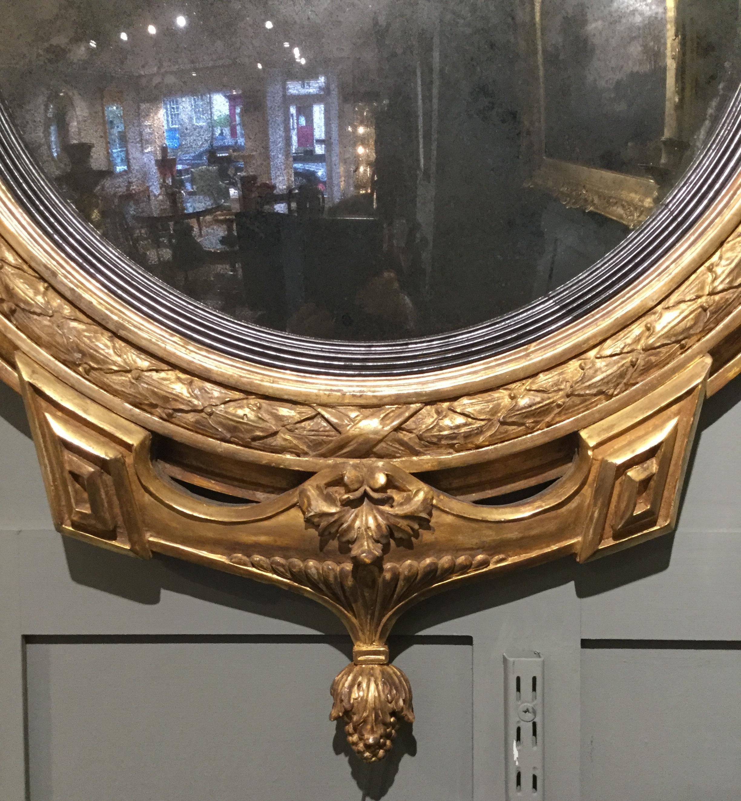 Irish period Regency gilt carved girandole convex mirror.