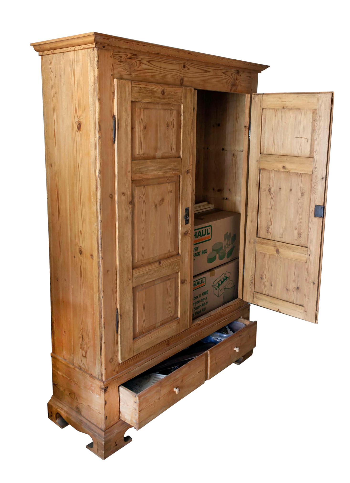 19thC European blonde pine armoire with two doors & a roomy bottom drawers.
Recessed panels on the doors. The bottom drawers appear to be 2 draws with center recess.
