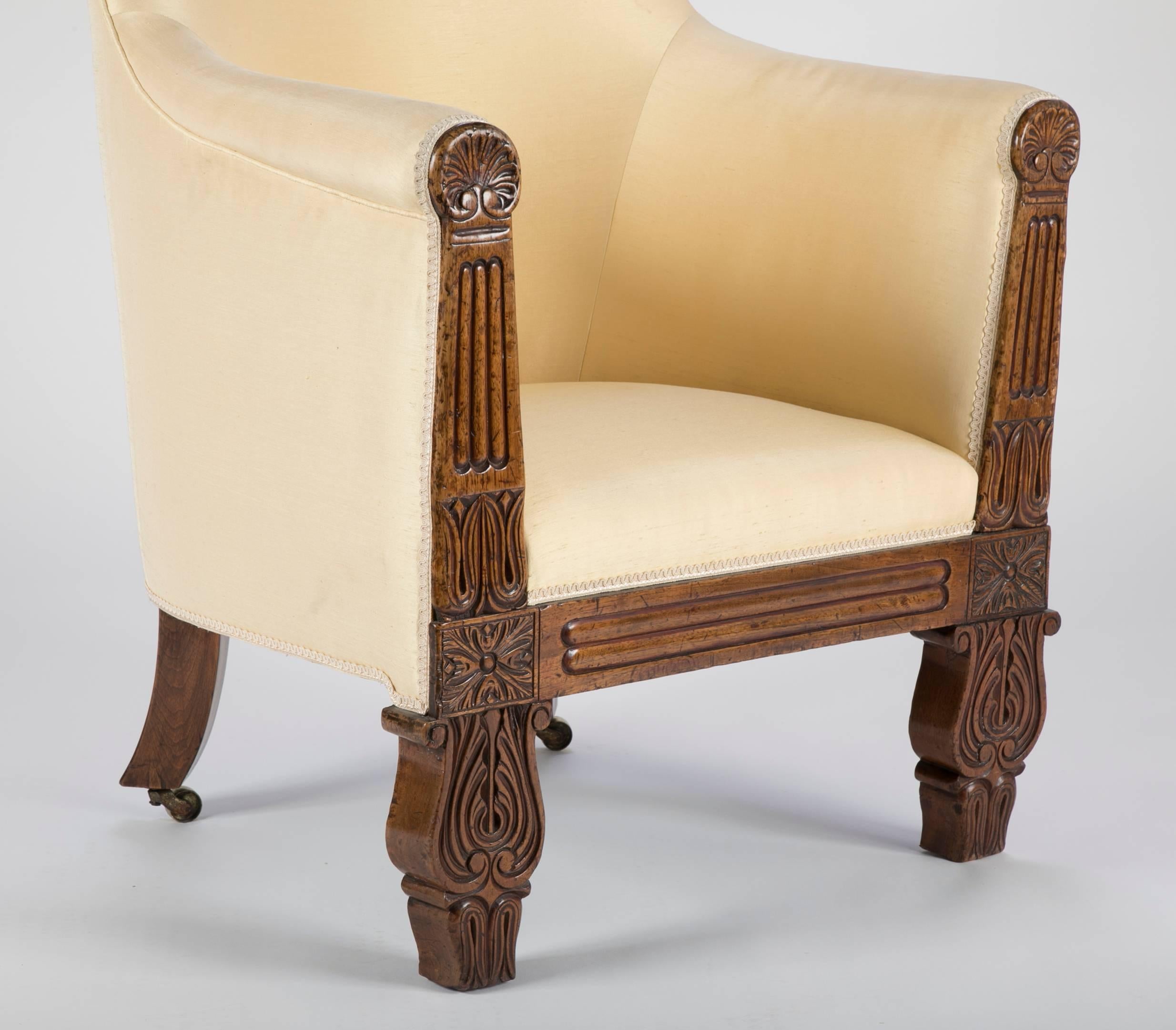 An early 19th century Irish Regency carved and upholstered walnut armchair.