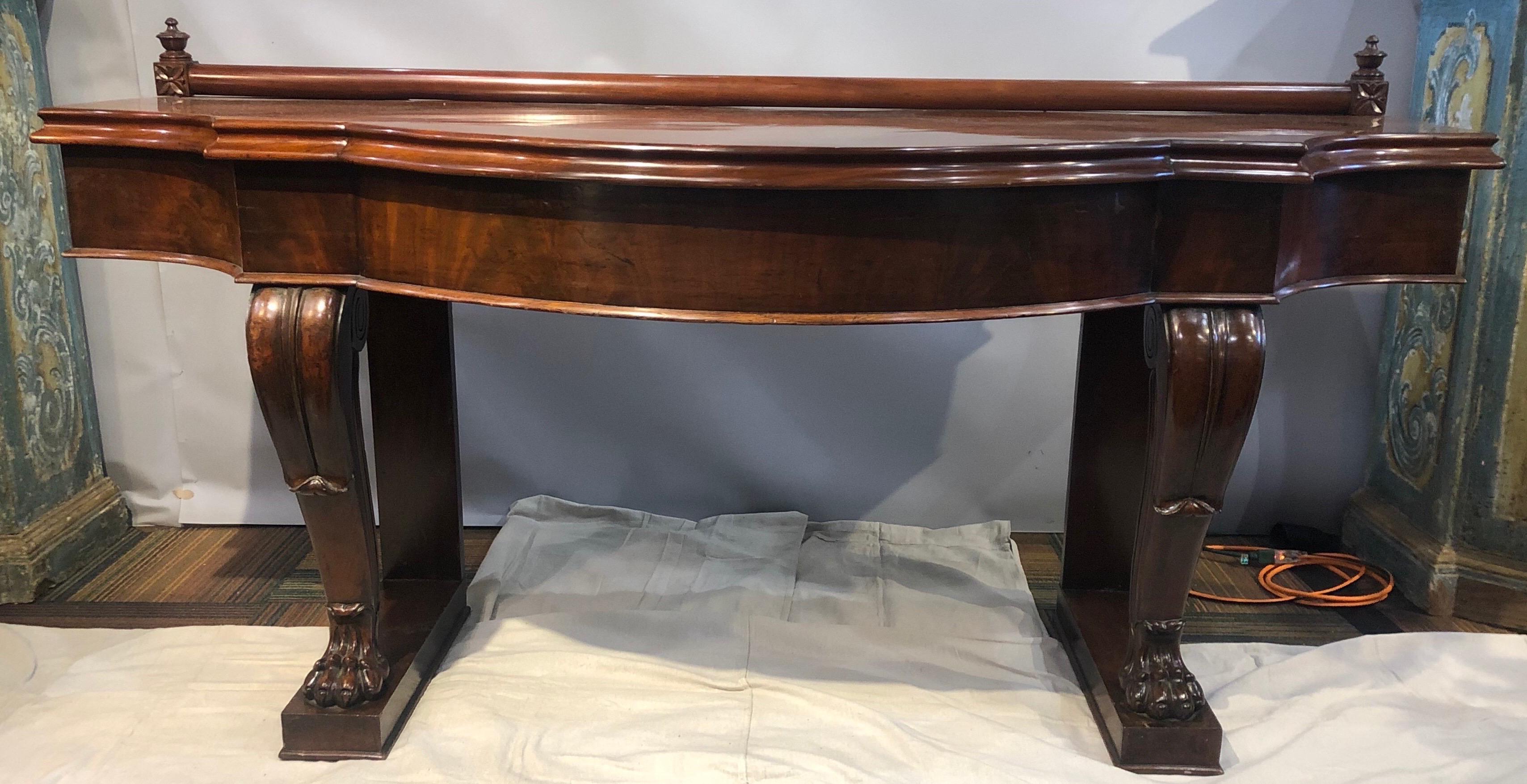 19th century Irish mahogany console. Solid serpentine top over carved paw feet.