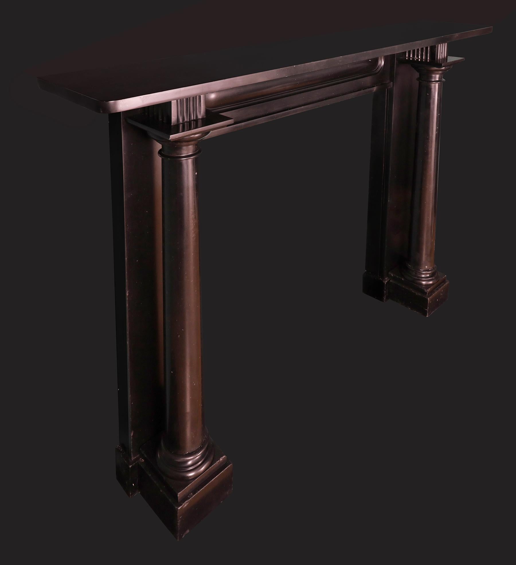 An Irish Regency Period Black Kilkenny Marble Fireplace Mantel. A substantial and superior quality chimneypiece in black Irish Kilkenny marble, early 19th century Regency period fireplace, with detached columns supported on square footblocks,