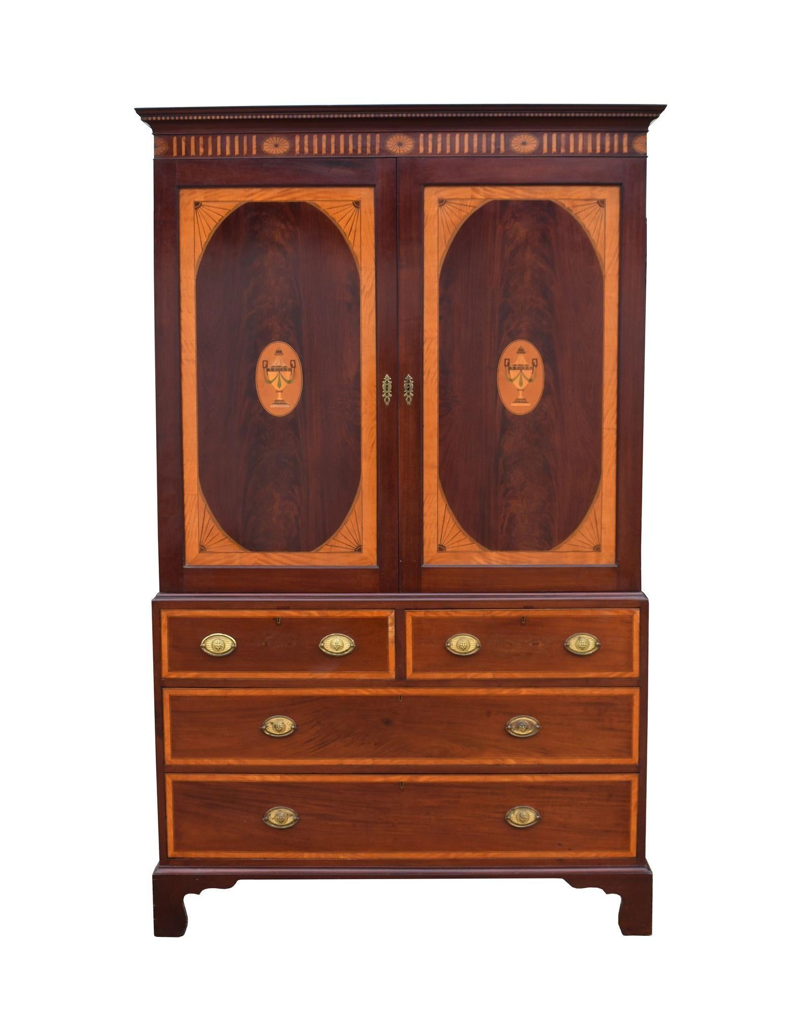 For sale is a good quality Victorian Irish Sheraton style inlaid mahogany linen press, having an inlaid pediment over two inlaid doors, opening to reveal three sliding trays. Below this, the linen press has an arrangement of four drawers, raised on