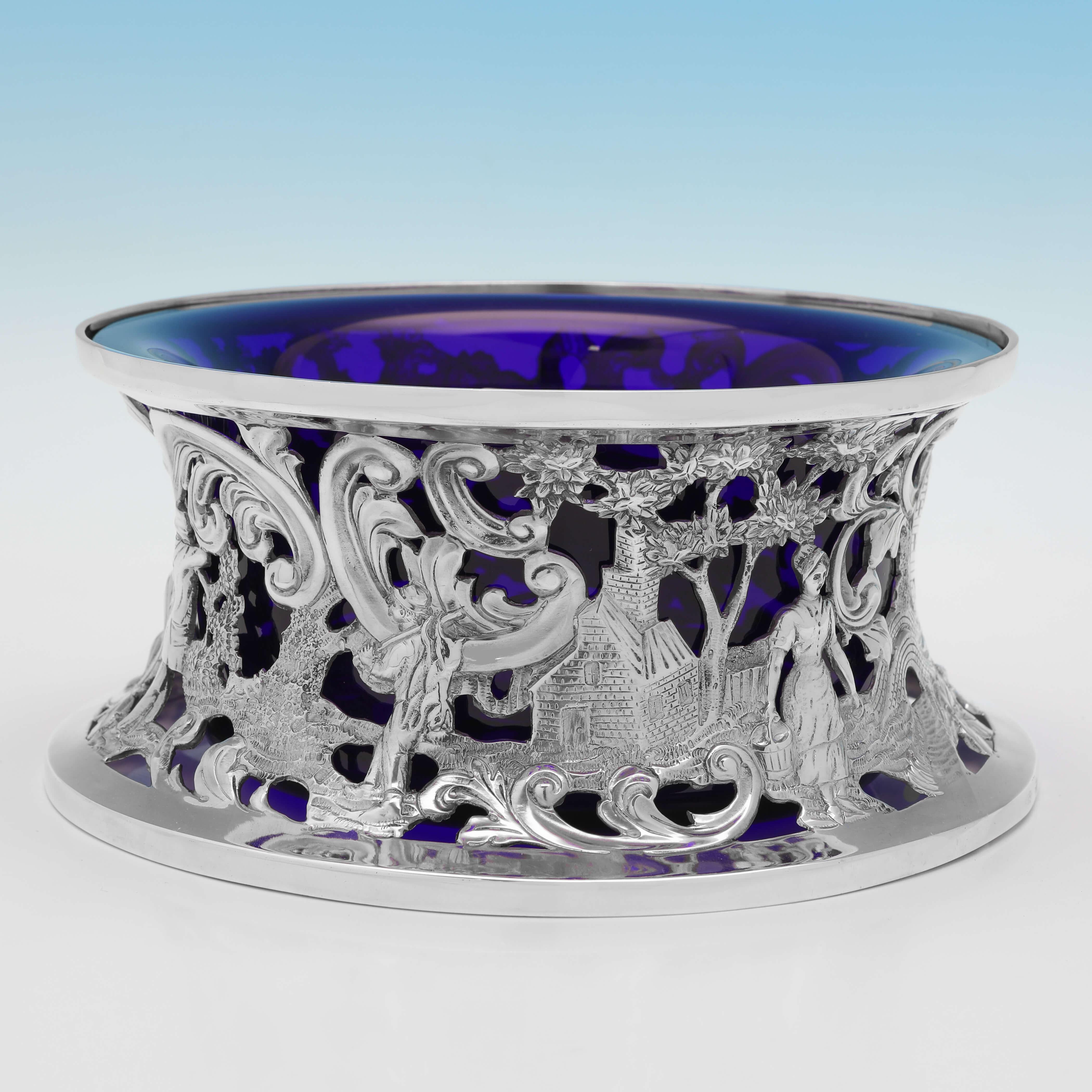 Marcada en Dublín en 1791 por Alexander Richards, esta encantadora sortija de plata de ley irlandesa de la época de Jorge III presenta una decoración cincelada y calada que representa escenas campestres, y un forro de cristal azul. 

El aro de plato