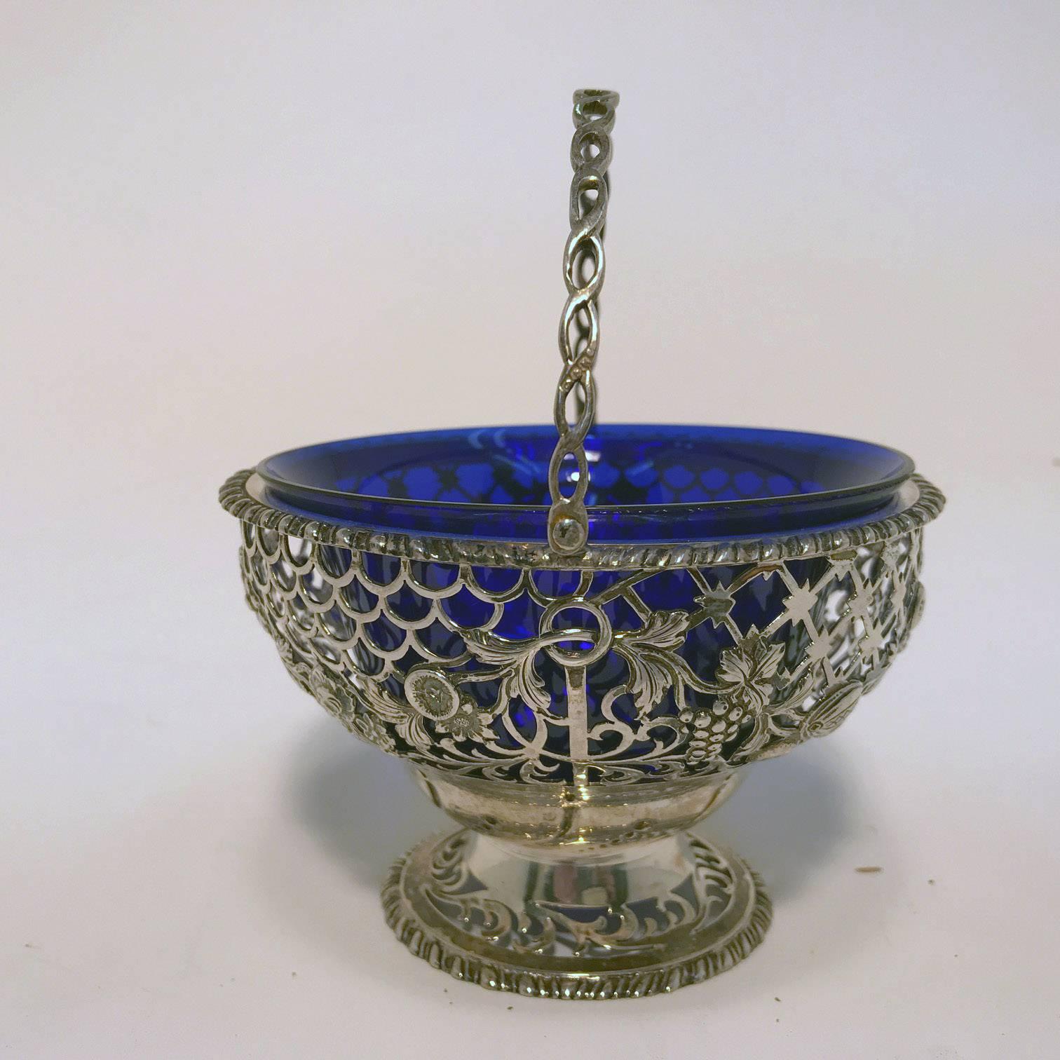 Pierced silver basket with cobalt blue glass liner and swing handle; hallmark for Wakely & Wheeler, Dublin, 1911. (173 g.).