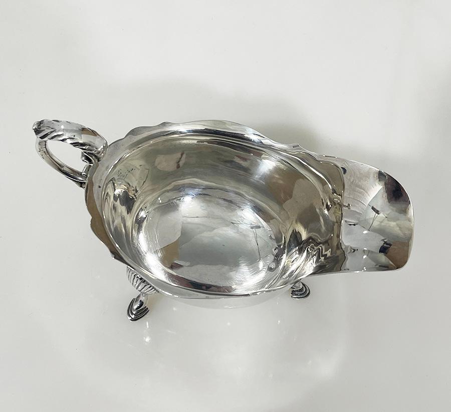Salsera de plata irlandesa de West & Son, Dublín, 1920

Salsera o salsera de plata irlandesa, fabricada por West & Son, Dublín, con borde perfilado y asa de voluta, elevada sobre tres pies de pezuña. El barco de plata tiene las marcas de plata