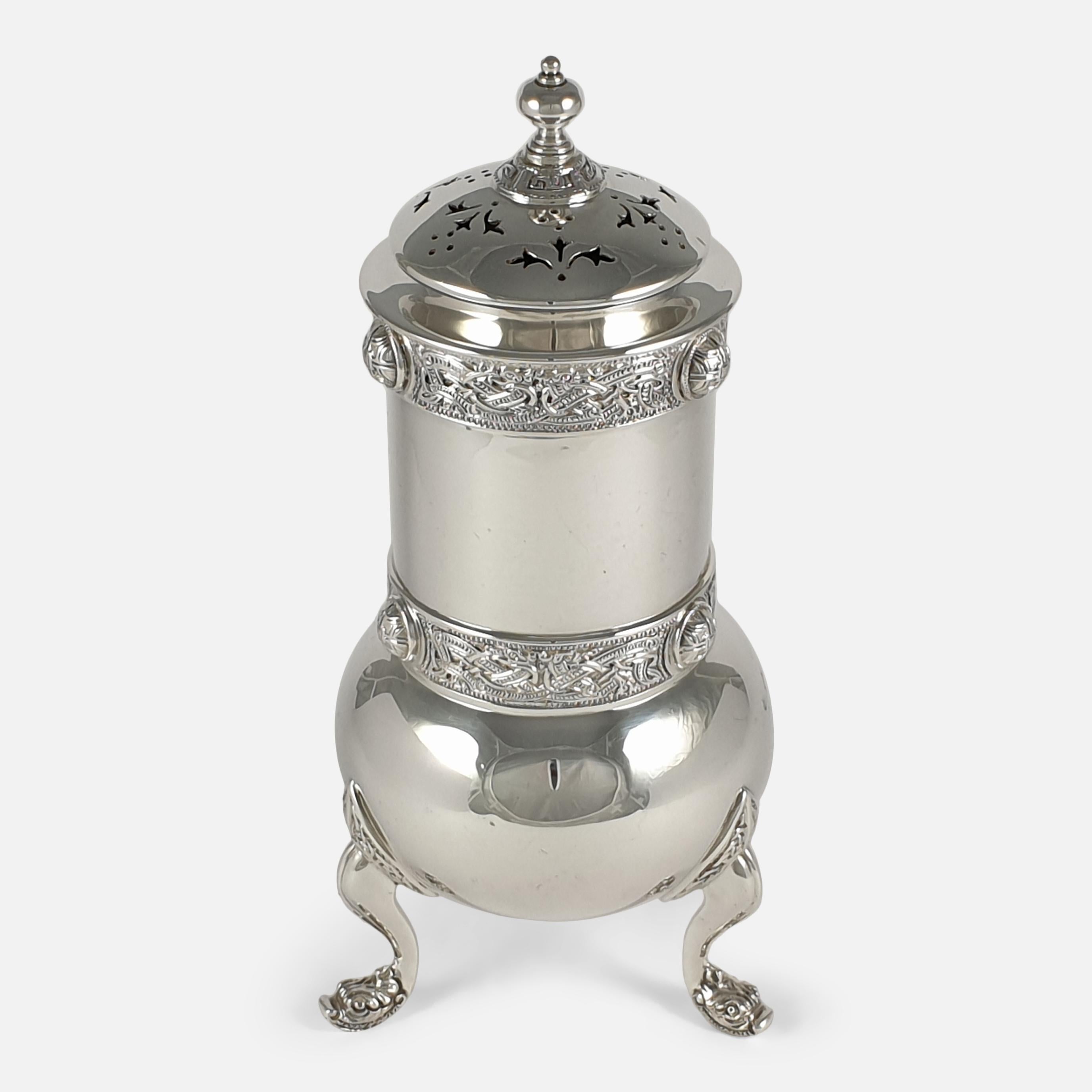 An antique Irish sterling silver sugar caster. The sugar caster is of cylindrical form with a pierced domed cover and knop finial, Celtic strap work decoration to the body, and feet modelled as stylized beasts' heads. 

It is Irish hallmarked with
