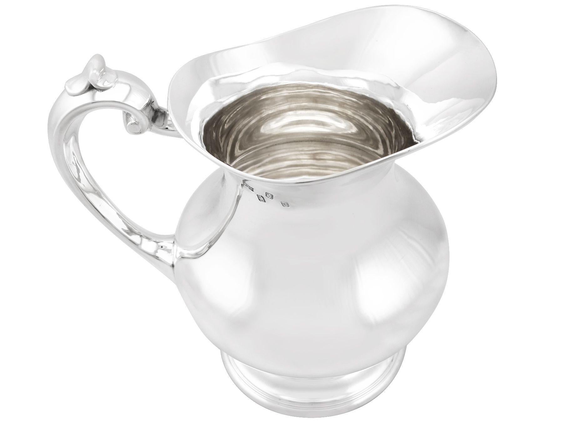 An exceptional, fine and impressive vintage Elizabeth II Irish sterling silver water jug; part of our vintage dining silverware collection.

His exceptional vintage Irish silver water jug, in sterling standard, has a plain baluster form onto a