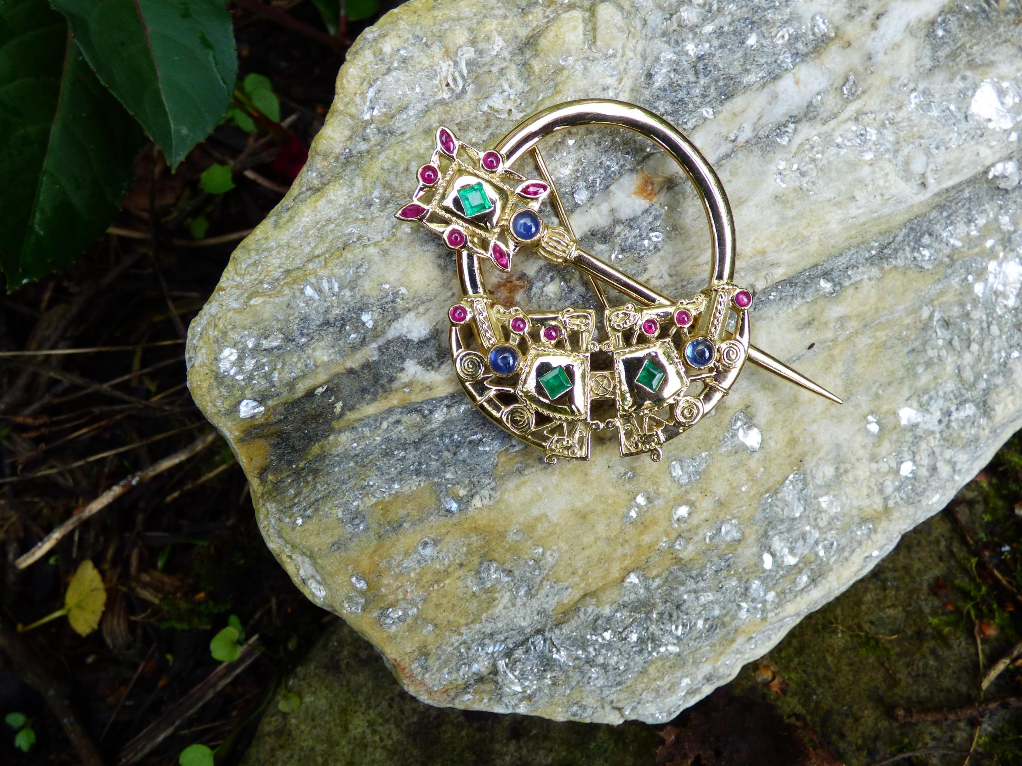 This unique Tara Brooch is set with 3 square Emeralds (.30ct.) cabochon and marquise cut Rubies (.90ct) and three cabochon Sapphires (.60ct.). This 18K yellow gold brooch has a self locking catch and is 50X50mm in size. Our pieces are content tested