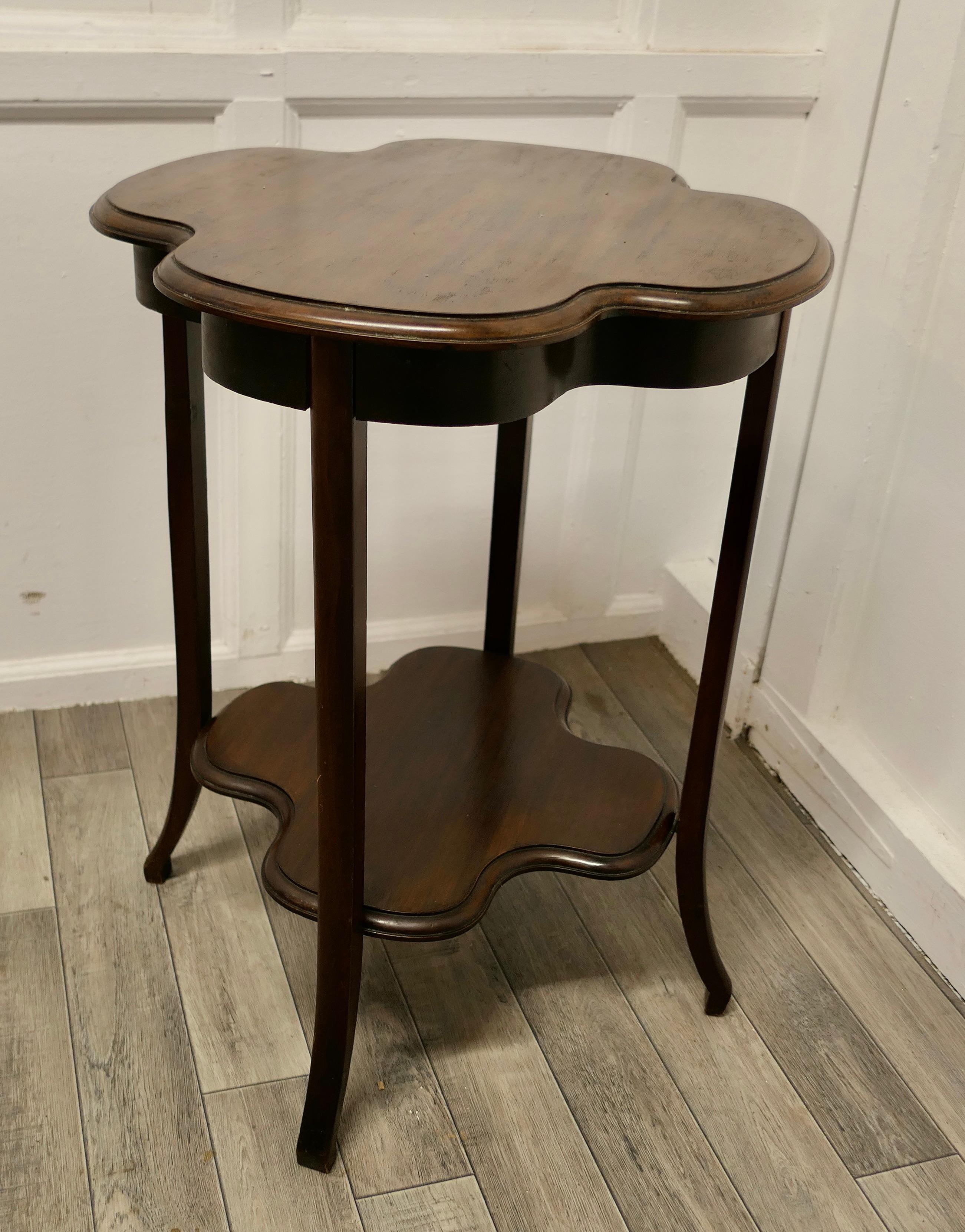 Irish Walnut side or lamp table.

The table has a four leaf clover shaped table top and the same shape undertier, it has slightly outward splayed legs.
The table is in very good condition and would work well as a side or lamp table as well as an