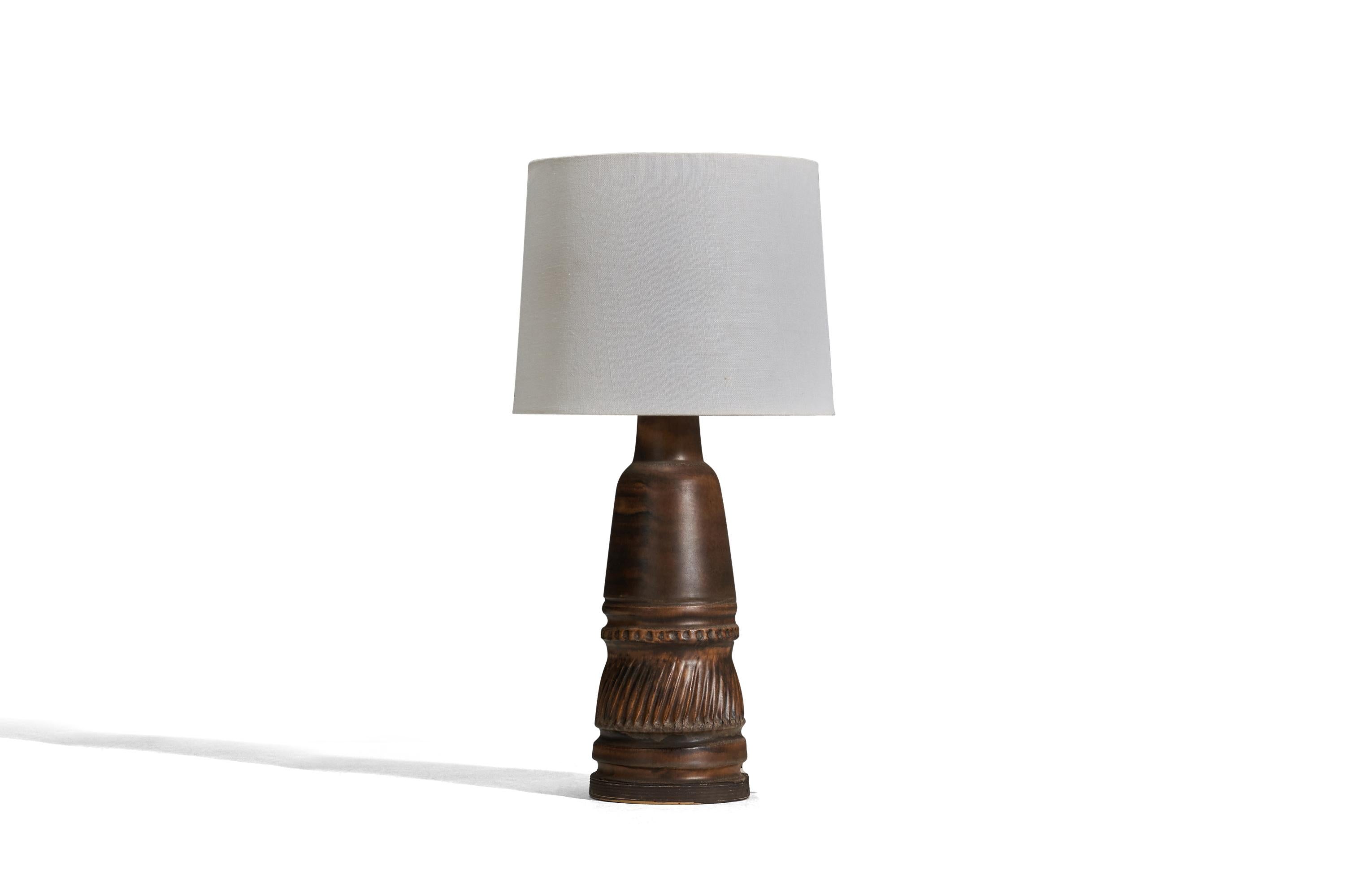 A brown glazed stoneware table lamp designed and produced by Irma Yourstone, Sweden, 1960s.

Sold without lampshade
Dimensions of lamp (inches) : 14.56 x 5.07 x 5.07 (Height x Width x Depth)
Dimensions of lampshade (inches) : 9 x 10 x 8 (Top