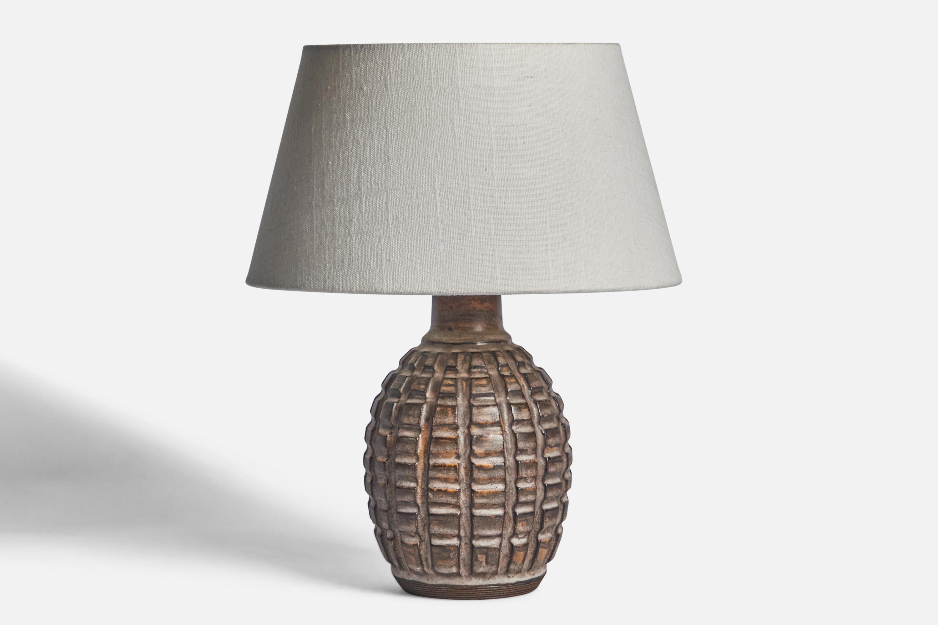 A brown-glazed stoneware table lamp designed and produced by Irma Yourstone, Sweden, c. 1960s.

Dimensions of Lamp (inches): 9.85” H x 4.75” Diameter
Dimensions of Shade (inches): 7” Top Diameter x 10” Bottom Diameter x 5.5” H 
Dimensions of Lamp