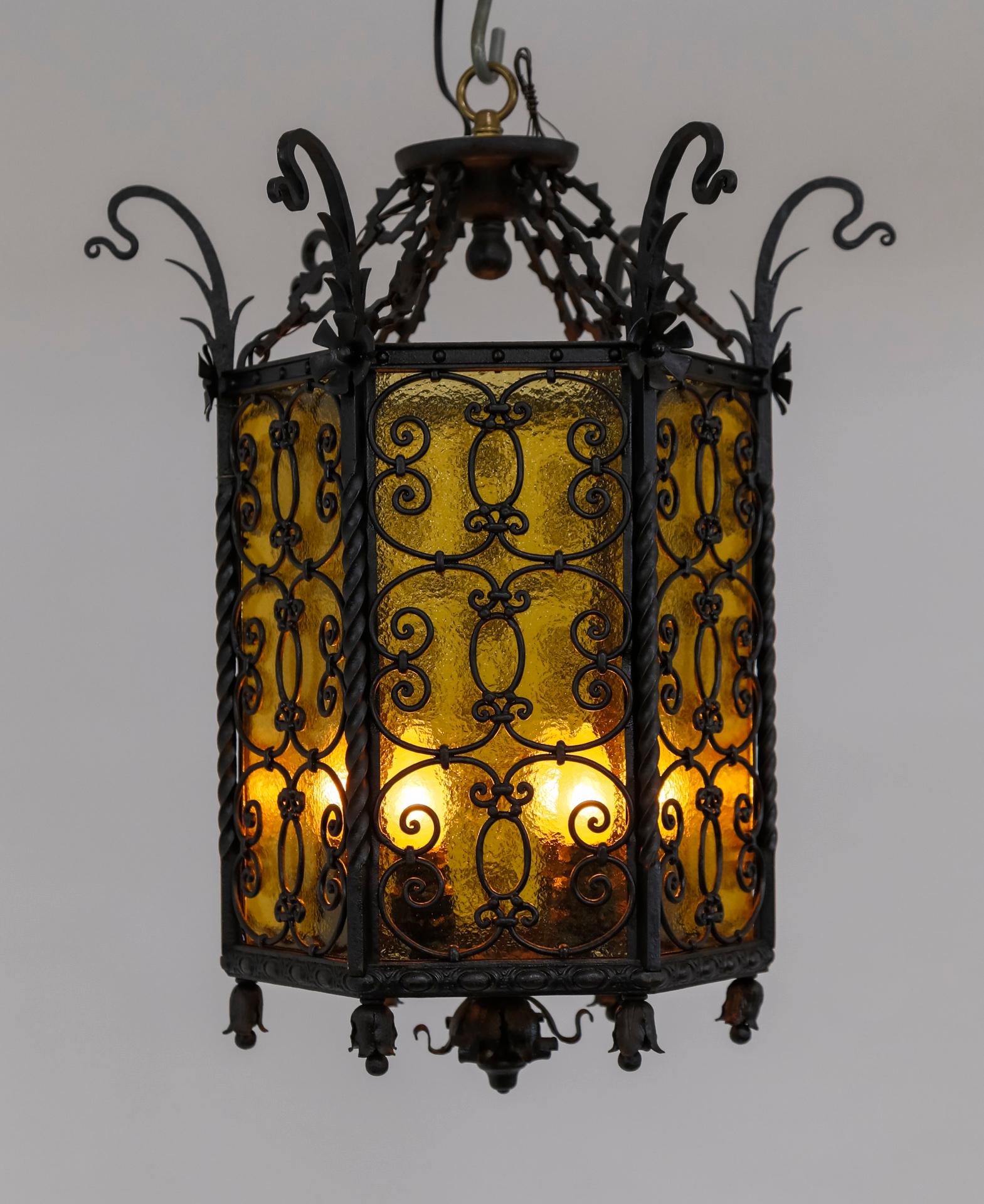 A slick, black wrought iron structure gives this early 20th century, semi-flush mount light fixture a striking appearance. It combines Gothic Revival and Art Nouveau styles, with notable whiplash curls, as well as egg-and-dart trim, stylized