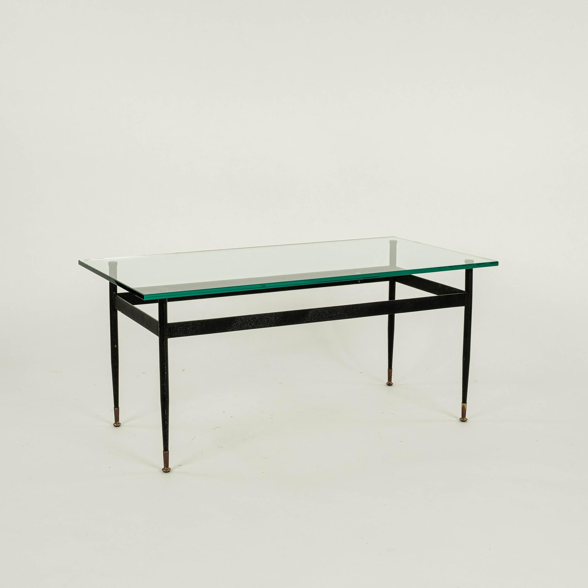 Mesa de cóctel de hierro y latón con patas cónicas con pies de latón, refuerzo de barra plana y tapa de cristal.