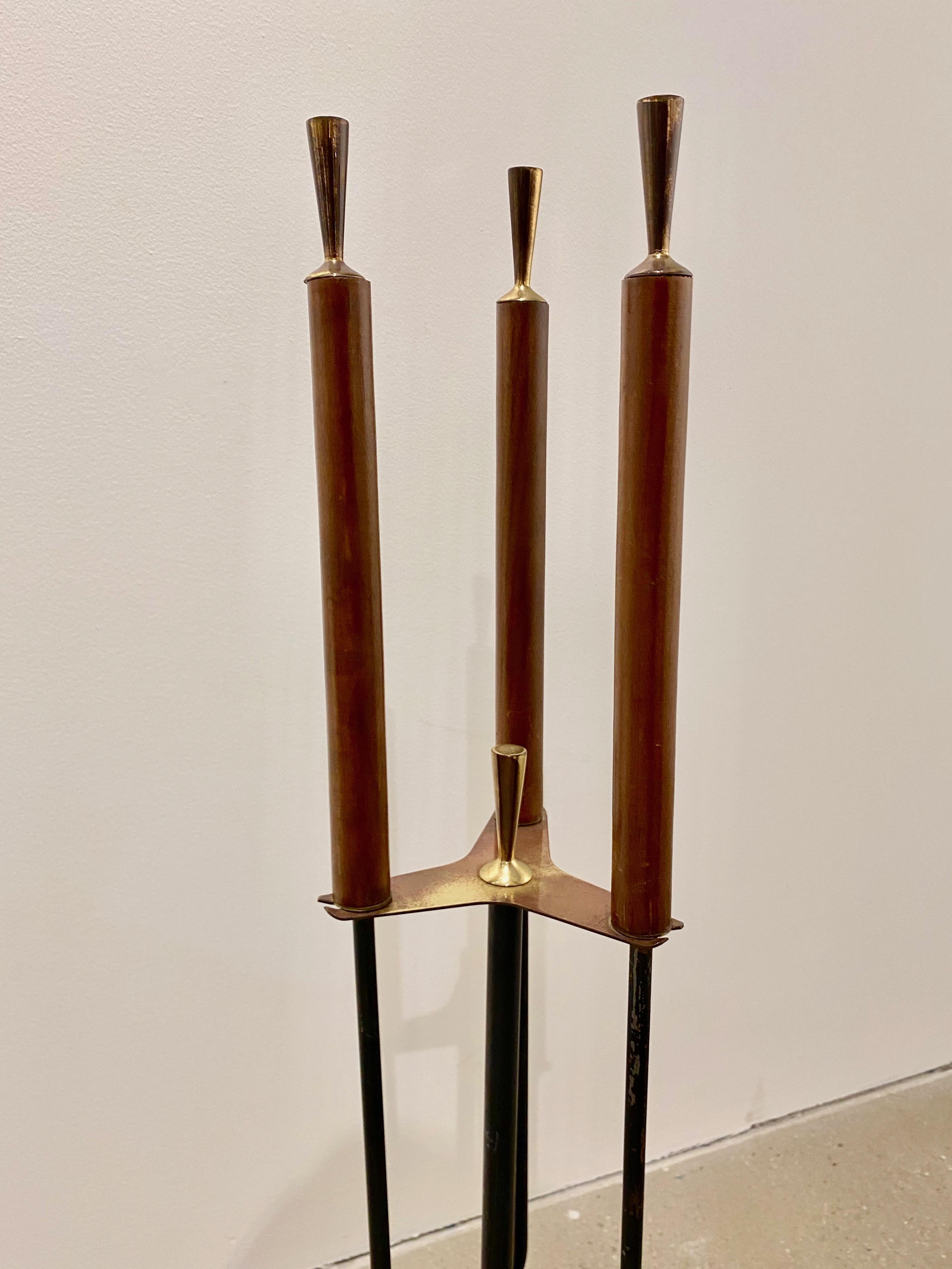 Modernist wood and brass propeller base fireplace tools.
