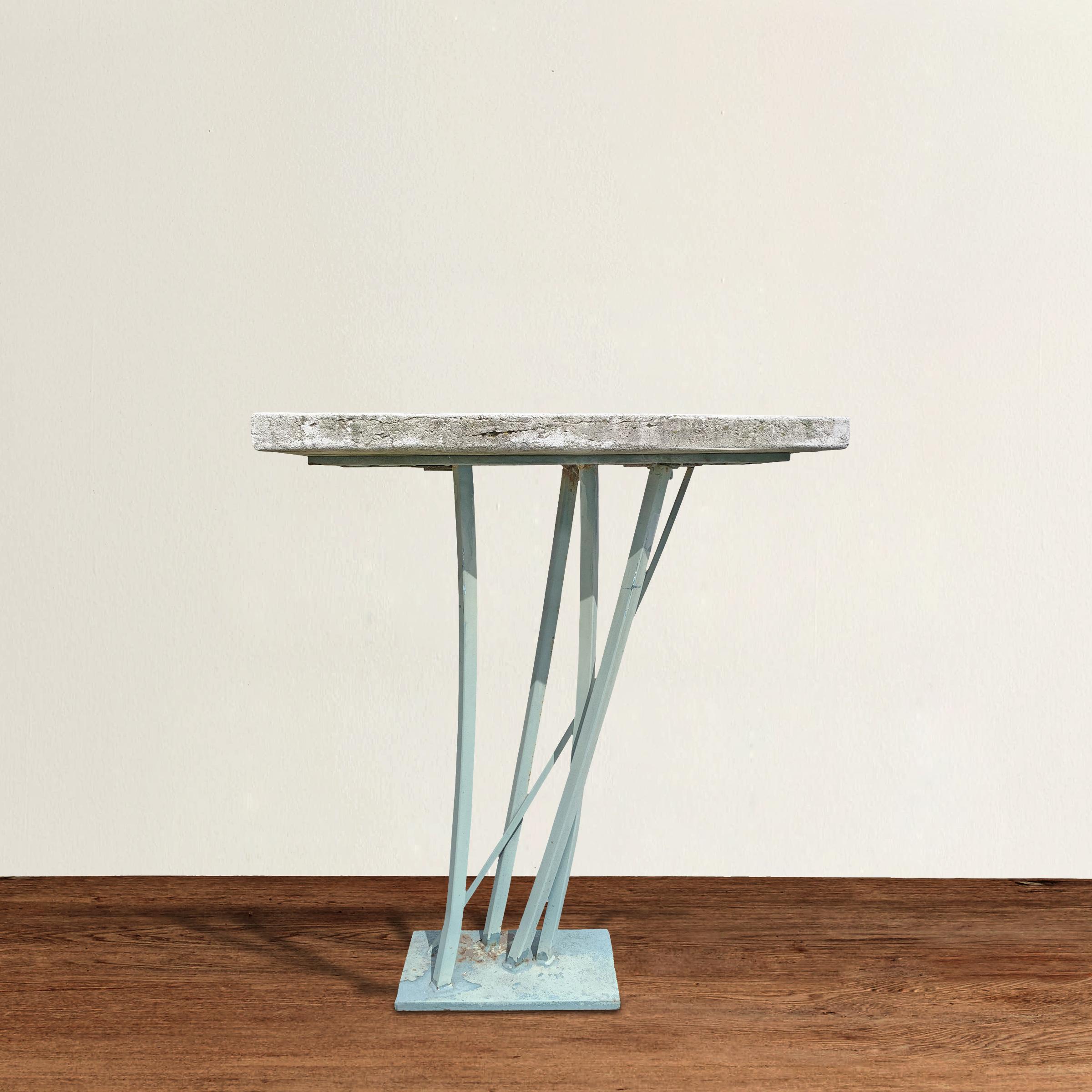 An iron and cast-stone top table by celebrated Detroit artist, Joseph Wesner, reminiscent of grasses blowing in the wind. This table has clearly lived its life outdoors having a wonderful patina on the top and faded turquoise paint on the base, but