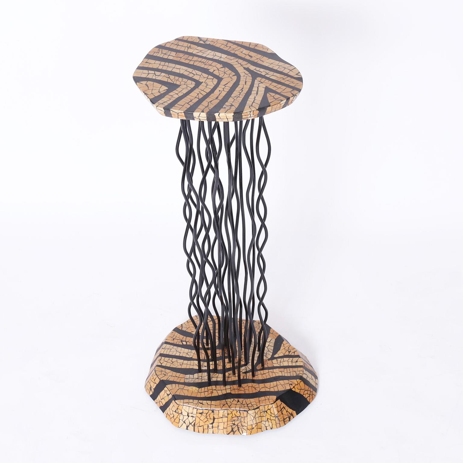 Standout modernist pedestal crafted with a coconut shell mosaic on the top and base having sculptural iron supports designed in a postmodern composition.
