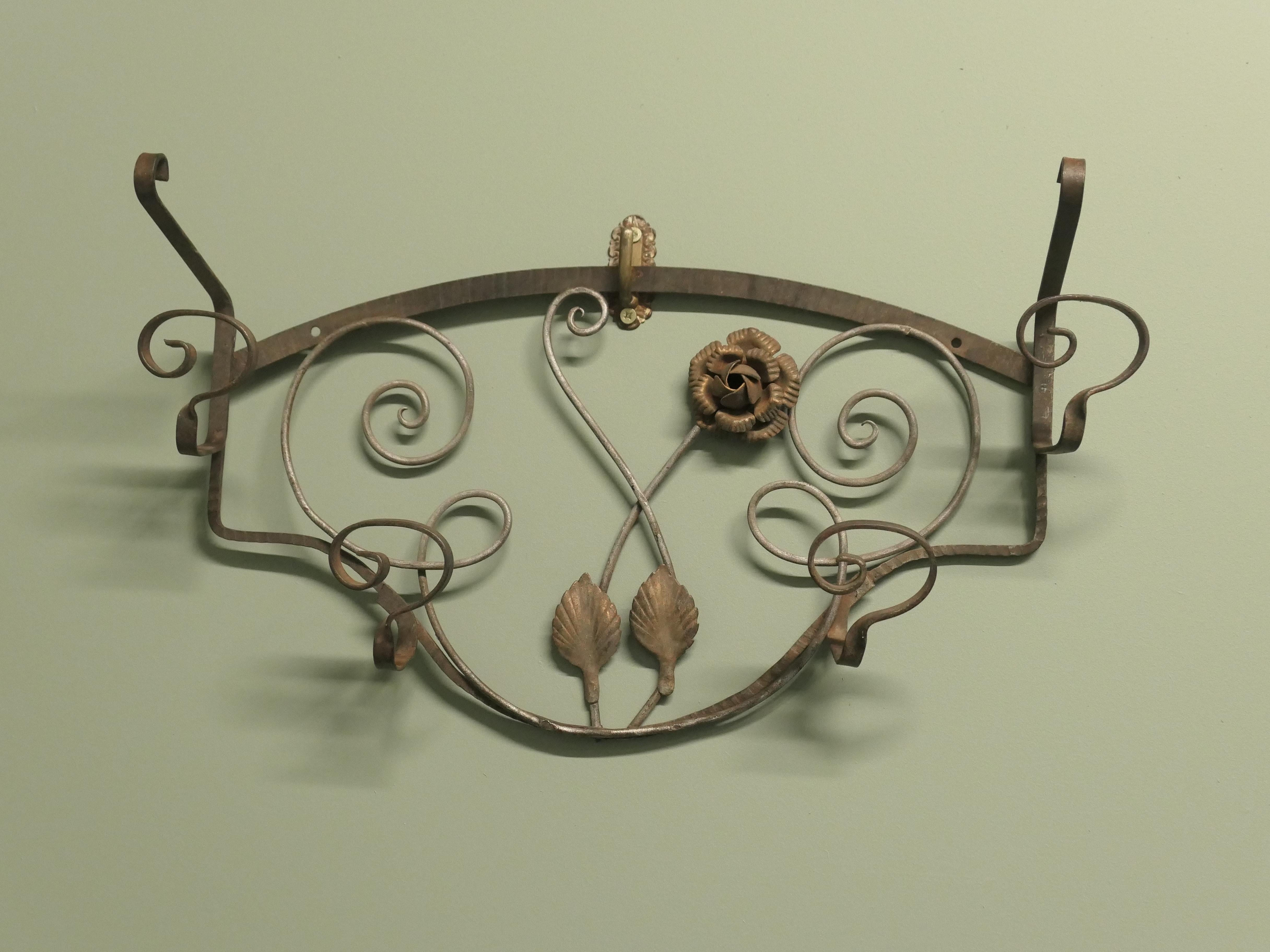 Appendiabiti da sala in ferro e dorato con specchio 

Si tratta di un grazioso appendiabiti da parete con 6 ganci per cappelli e cappotti, con decorazione a rose e foglie dorate.
Il rack è lungo 22