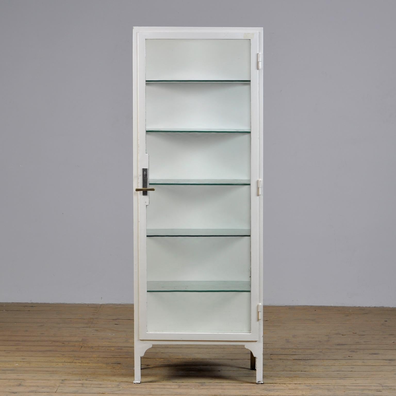 Medical cabinet from the 1930s. The cabinet is produced in hungary and is made of thick iron and antique glass. With the original glass shelves of 8mm thick. The glass plates have a green tint. The lock and handle are also original and functional. 