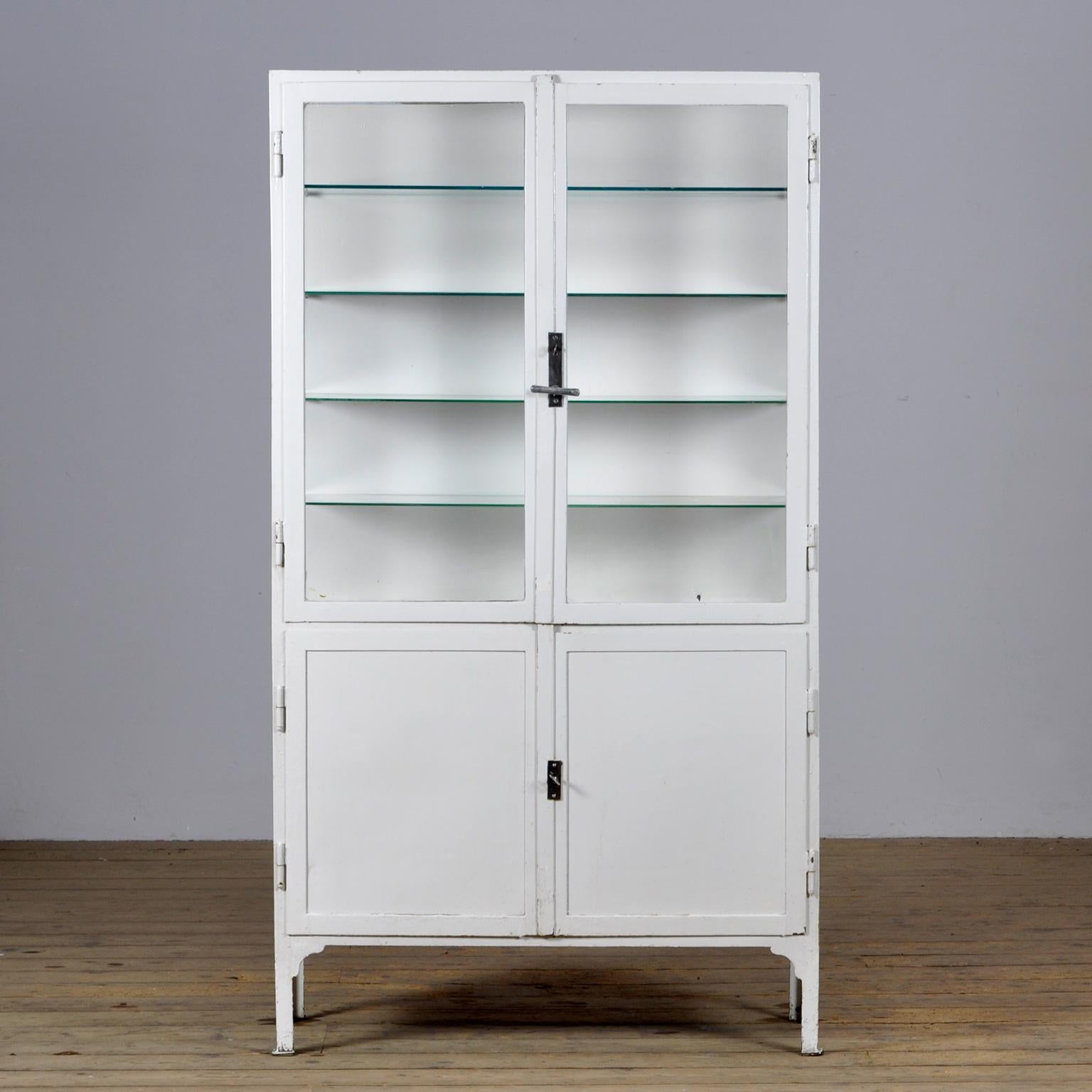 Medical cabinet from the 1930s. The cabinet is produced in hungary and is made of thick iron and antique glass. The locks and handle are functional.