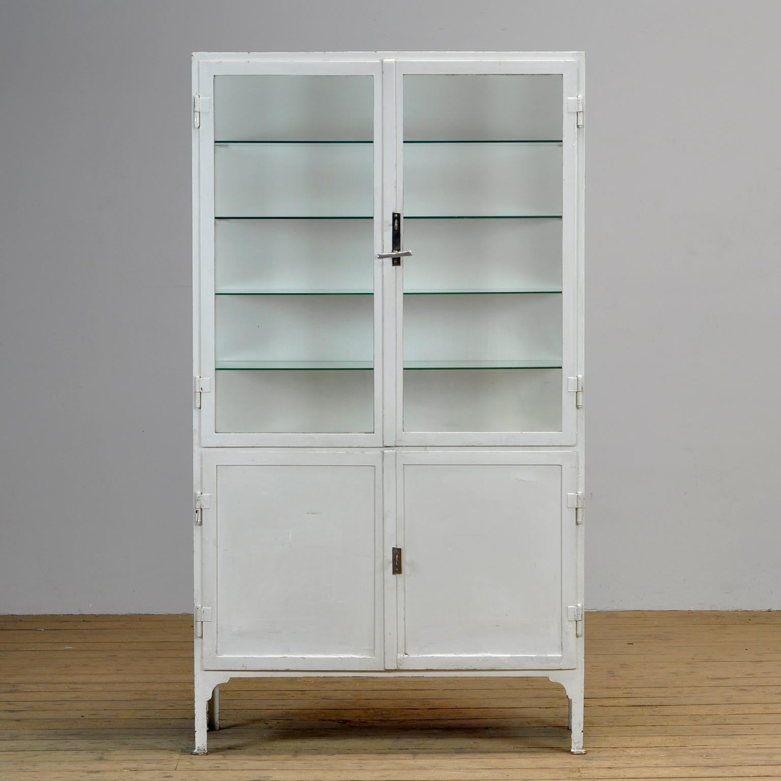 Medical cabinet from the 1930s. The cabinet is produced in hungary and is made of thick iron and antique glass. The locks and handle are original and functional.
