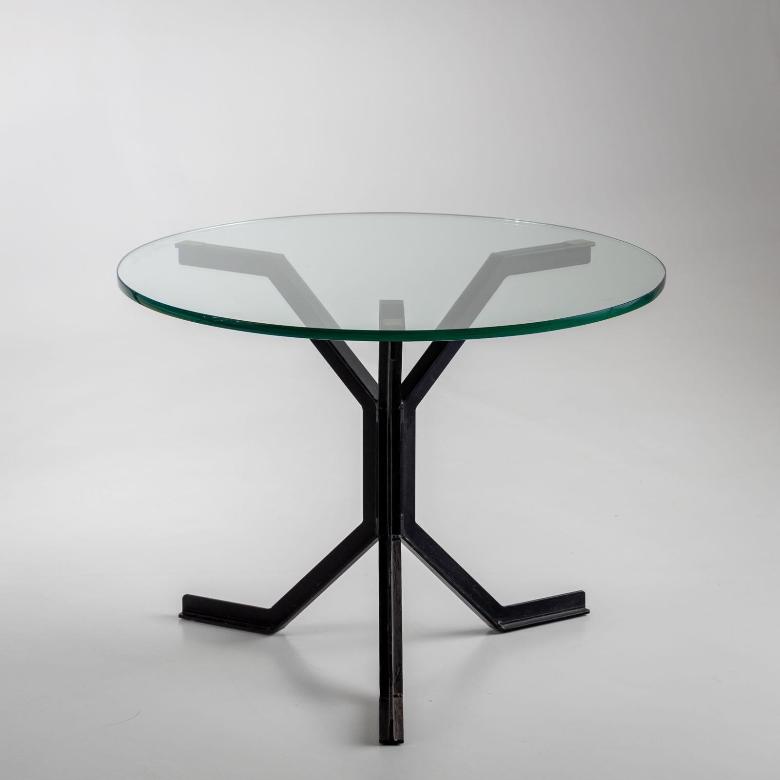 Pair of side tables with round glass tops and three-legged iron frames made of black lacquered T-beams. 