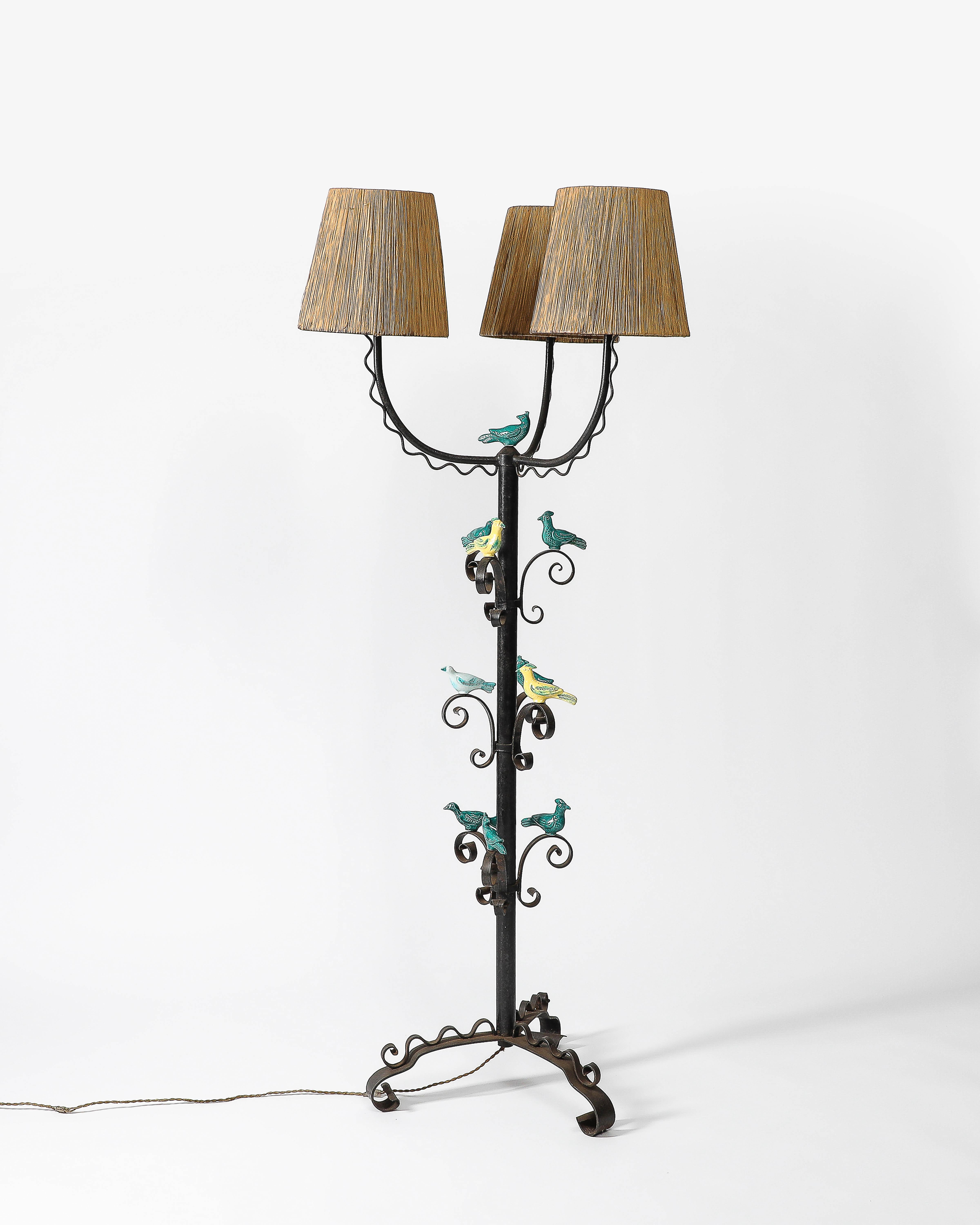 Original wiring.

Handmade, unique floor lamp made of wrought iron with glazed ceramic birds that sit on spikes throughout. The original rope shades complete this piece.