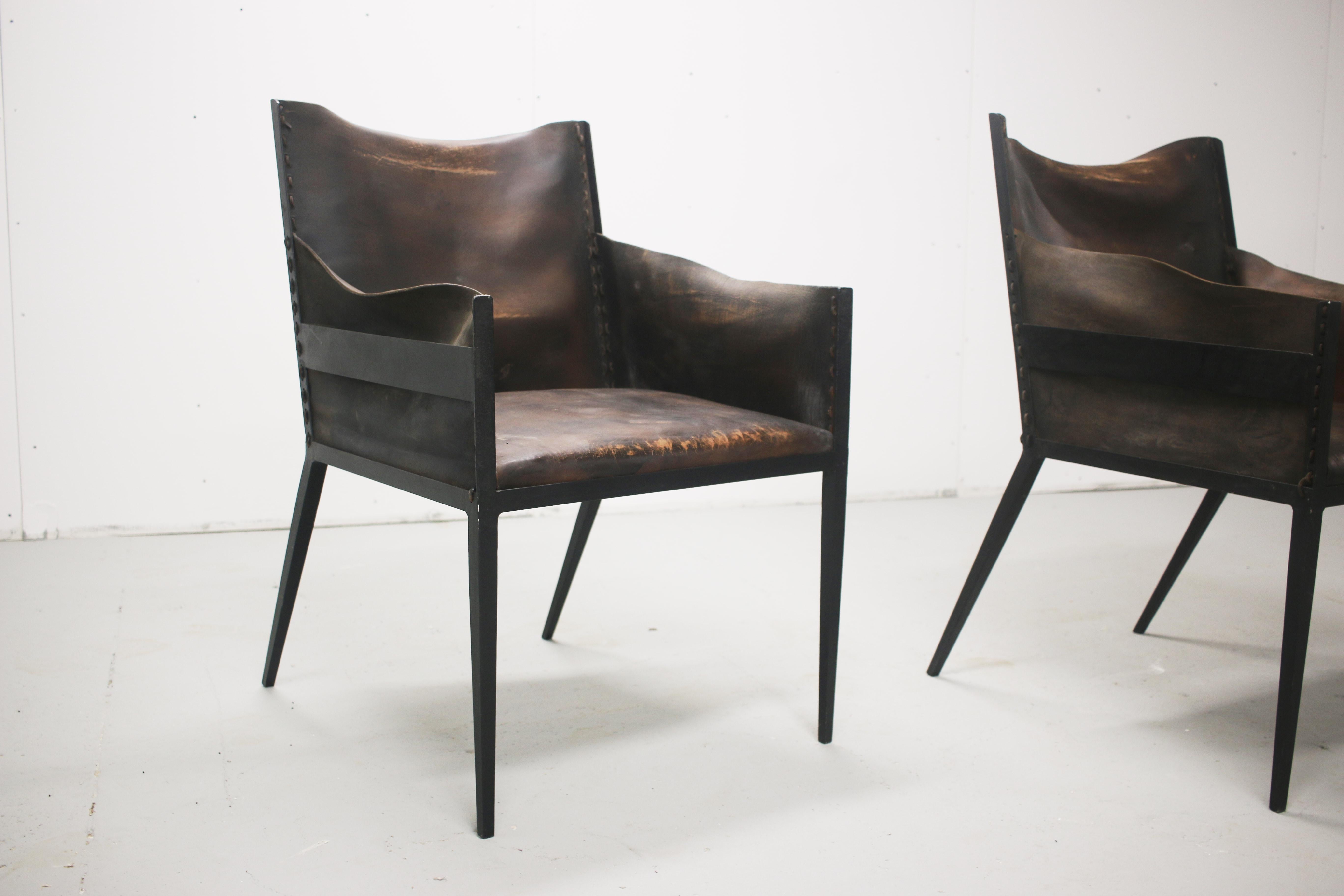 Iron and leather chairs, in the manner of Jean-Michel Frank, France. Signs of use and wear. 

Measures: 23 7/16” wide, 27 3/8” deep, 35 1/2” high
- seat is 21 1/2” wide, 19 7/8 deep, 18” high, cushions 1 1/4” thick.