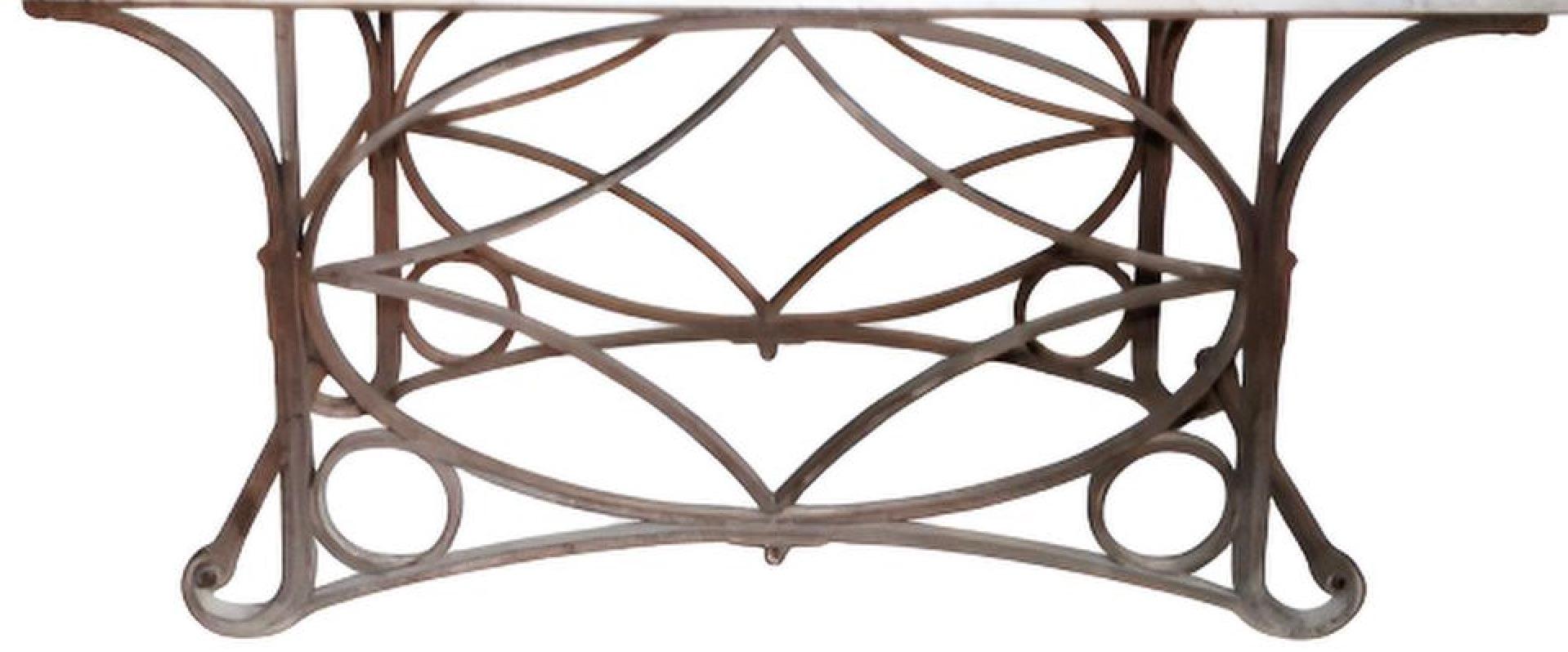 A spectacular and elegant table featuring a striking white marble top paired with a beautifully crafted wrought iron base. The ironwork consists of gracefully looping and intersecting rods, forming a sculptural and airy framework that is both