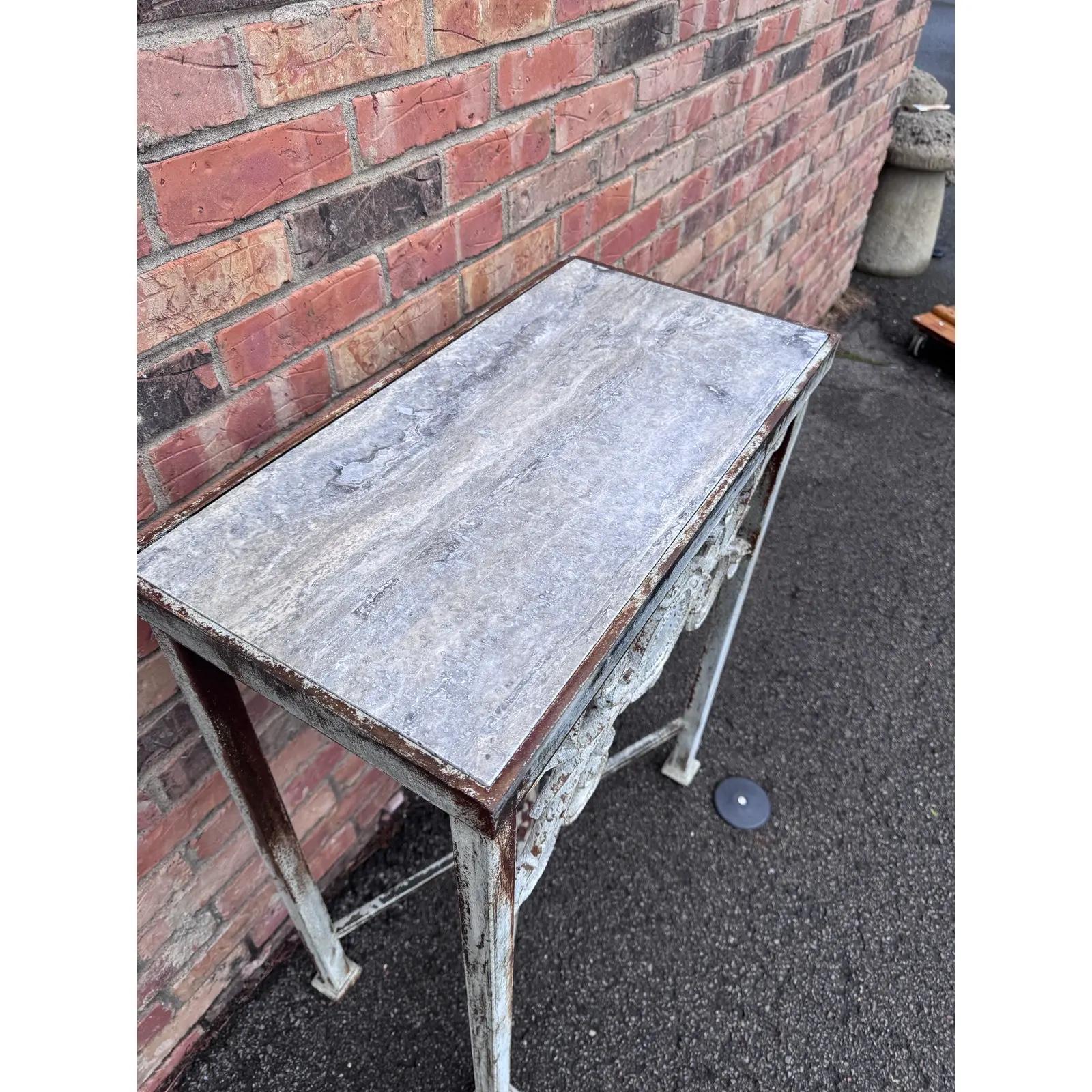 Se trata de una preciosa consola de hierro de fabricación local con un bonito acabado de zinc envejecido, que también cuenta con una tapa de mármol para una versatilidad en exteriores sin necesidad de mantenimiento. Esta mesa permitiría un estilo de