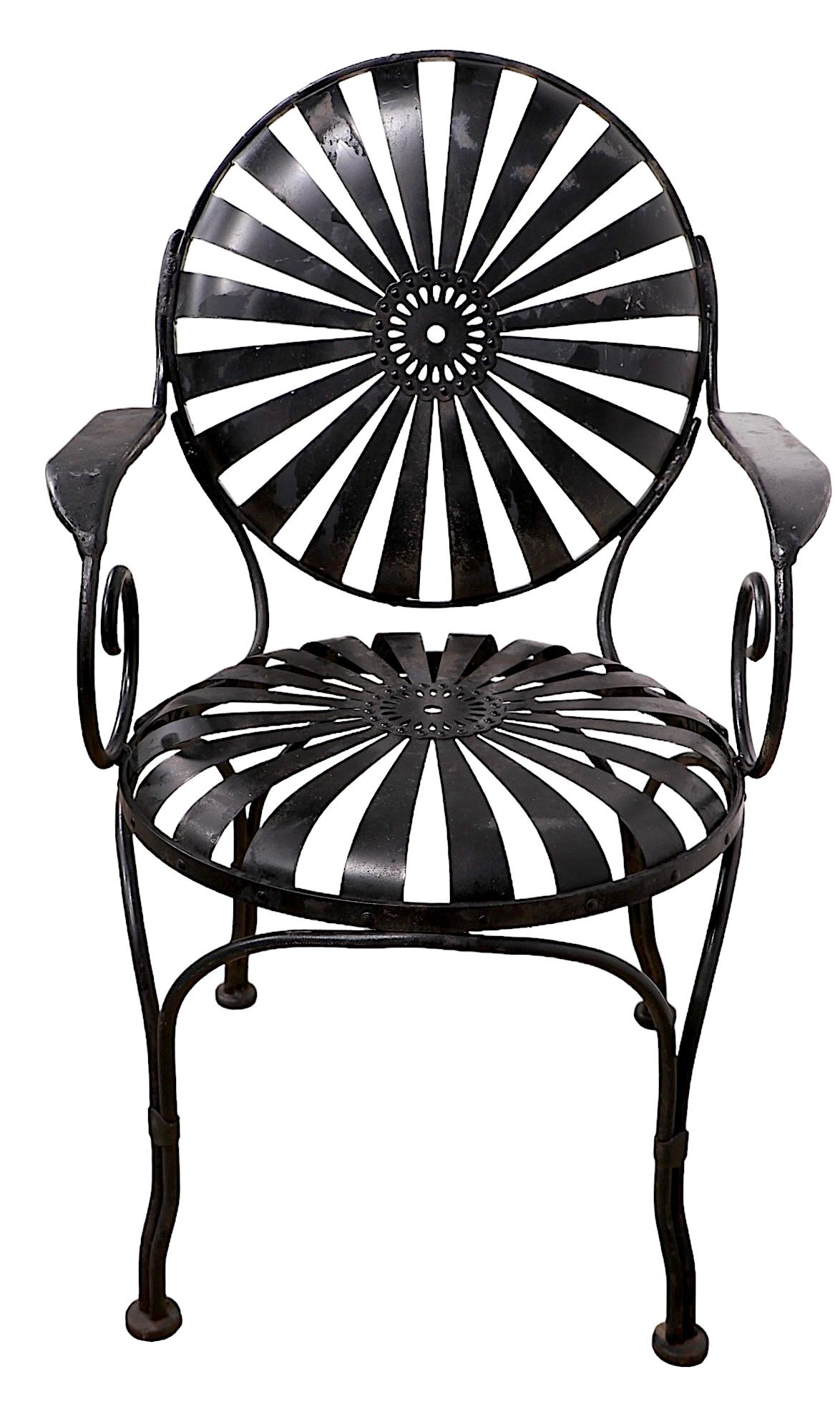 Fauteuil en métal chic et élégant de François Carrs, fabriqué en France vers les années 1940. La chaise est dotée d'une assise et d'un dossier à ressorts constitués de pédales en métal plat répétées qui rayonnent à partir du médaillon central. Les