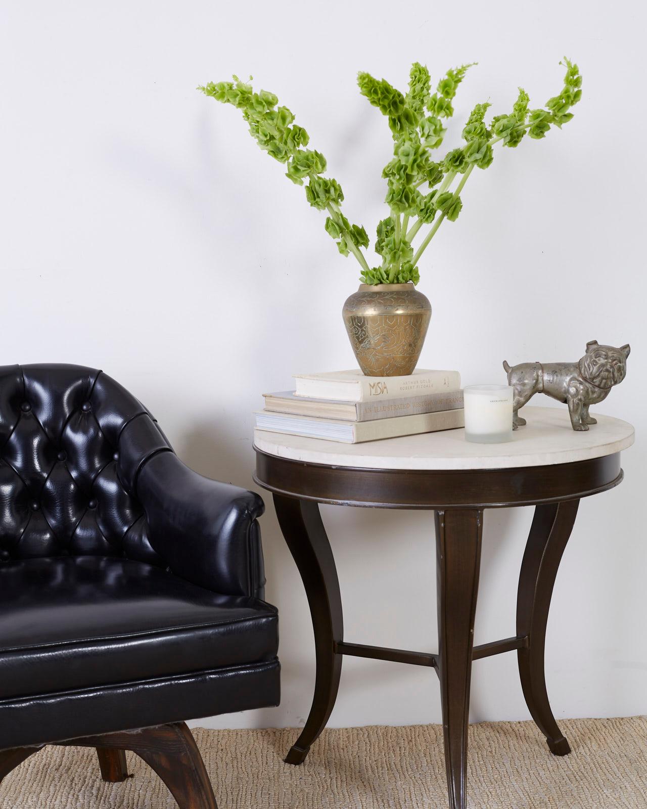 Attractive center table or drinks table constructed from iron with a lovely painted finish. Features a round, natural stone top with a matte, unhoned finish. Made by a foundry in Los Angeles, CA. Supported by three stylish saber legs in an hourglass