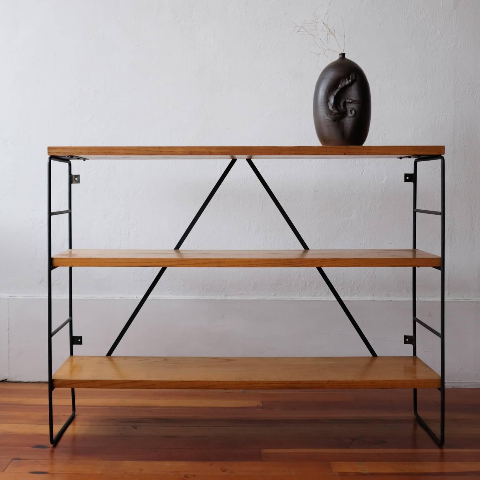 1950s iron and wood shelf. Solid wood shelves and iron frame. Well-built and extremely sturdy. The design includes tabs on the back so that it can be attached to a wall, if desired.