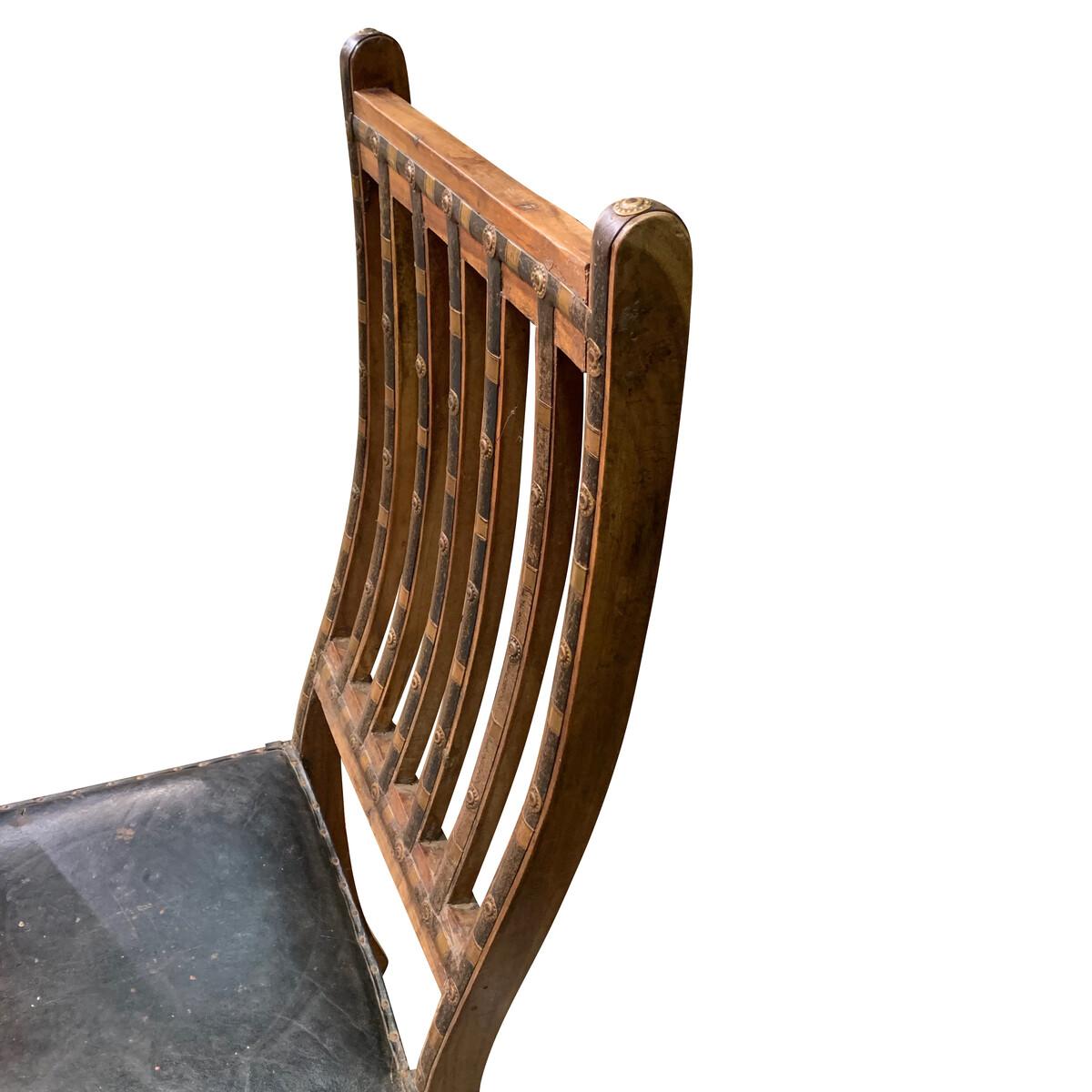 19th century Indian single chair with decorative iron bands and bronze studs
along the back seat and legs.
The spindled back is curved.
The black leather seat is original to the chair.

      
