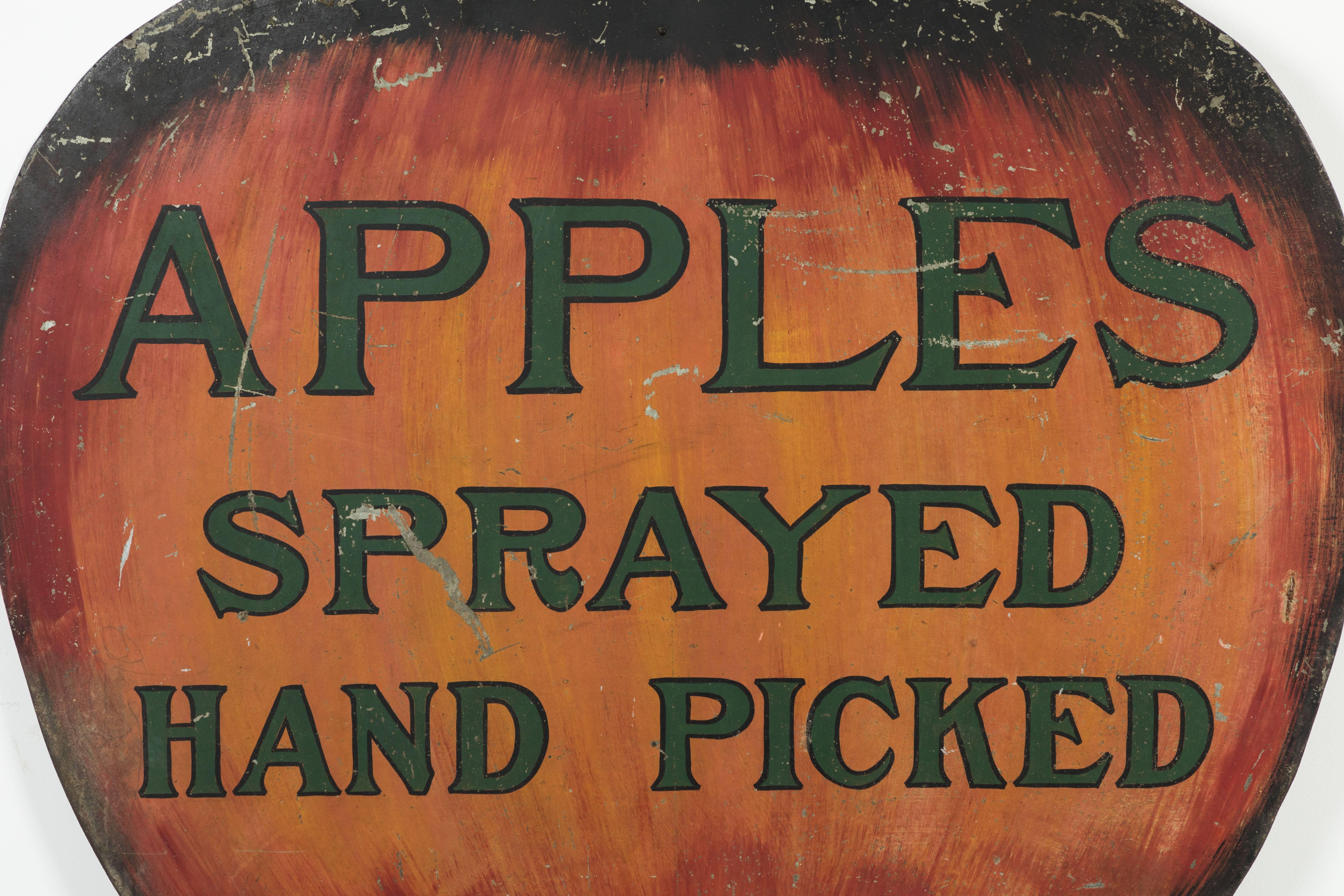 Vintage heavy sheet iron trade sign with fantastic subject matter. Giant apple with original paint surface and excellent hand lettering. Very dynamic piece of American Folk Art. Heavy iron hooks on bottom.